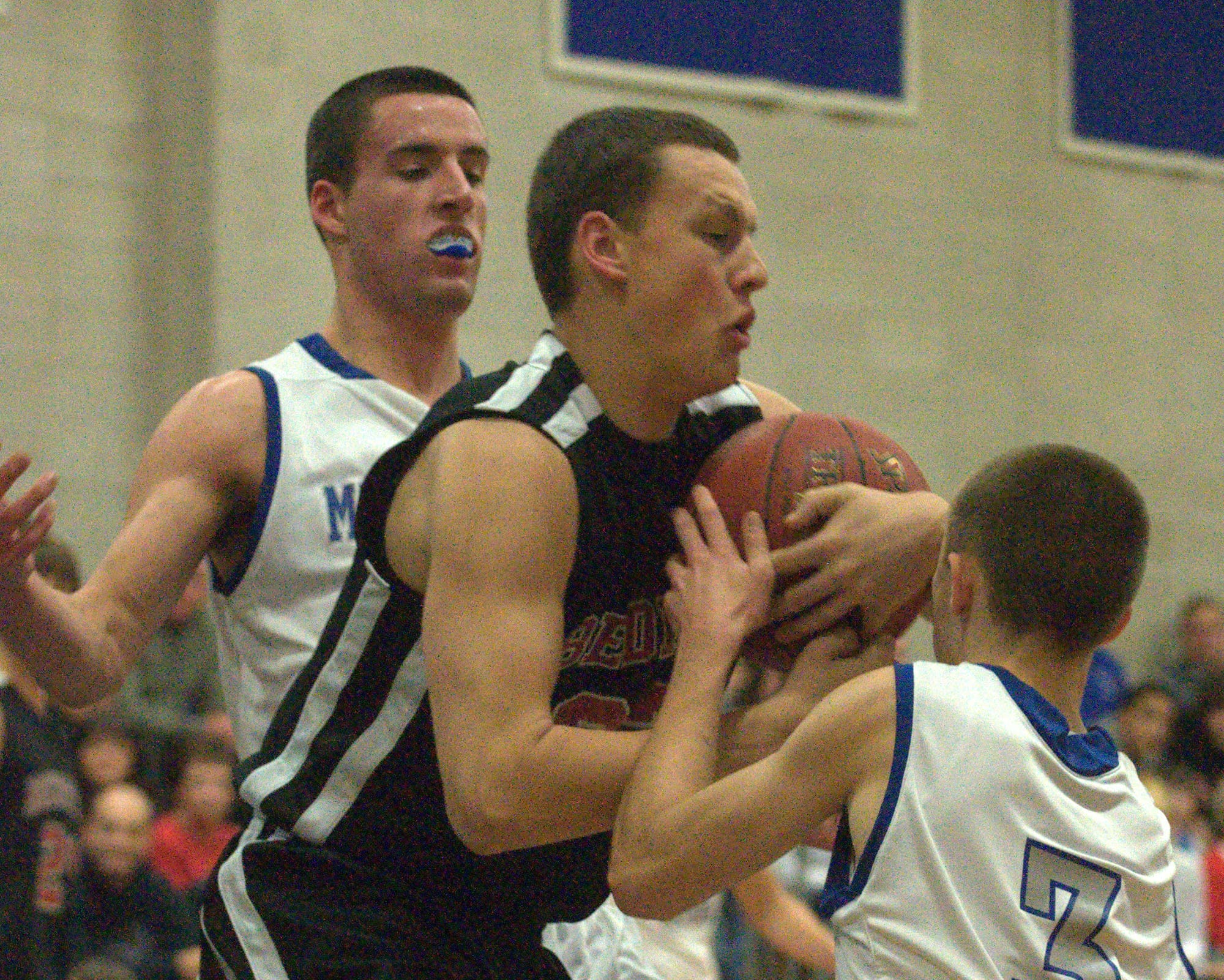 Bedford's Ryan Brown pulls a rebound away from Merrimack's Austin Franzen and Connor Whalen during Thursday's game. For more photos, go to the Photo Album.