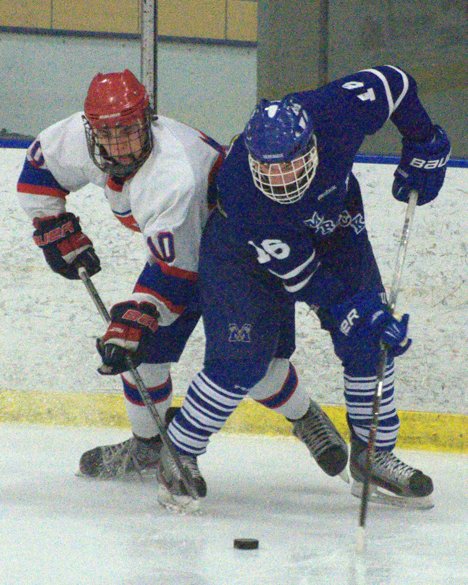 Merrimack's Jason Fortin and Trinity's Kyle Valliere battle for a loose puck.