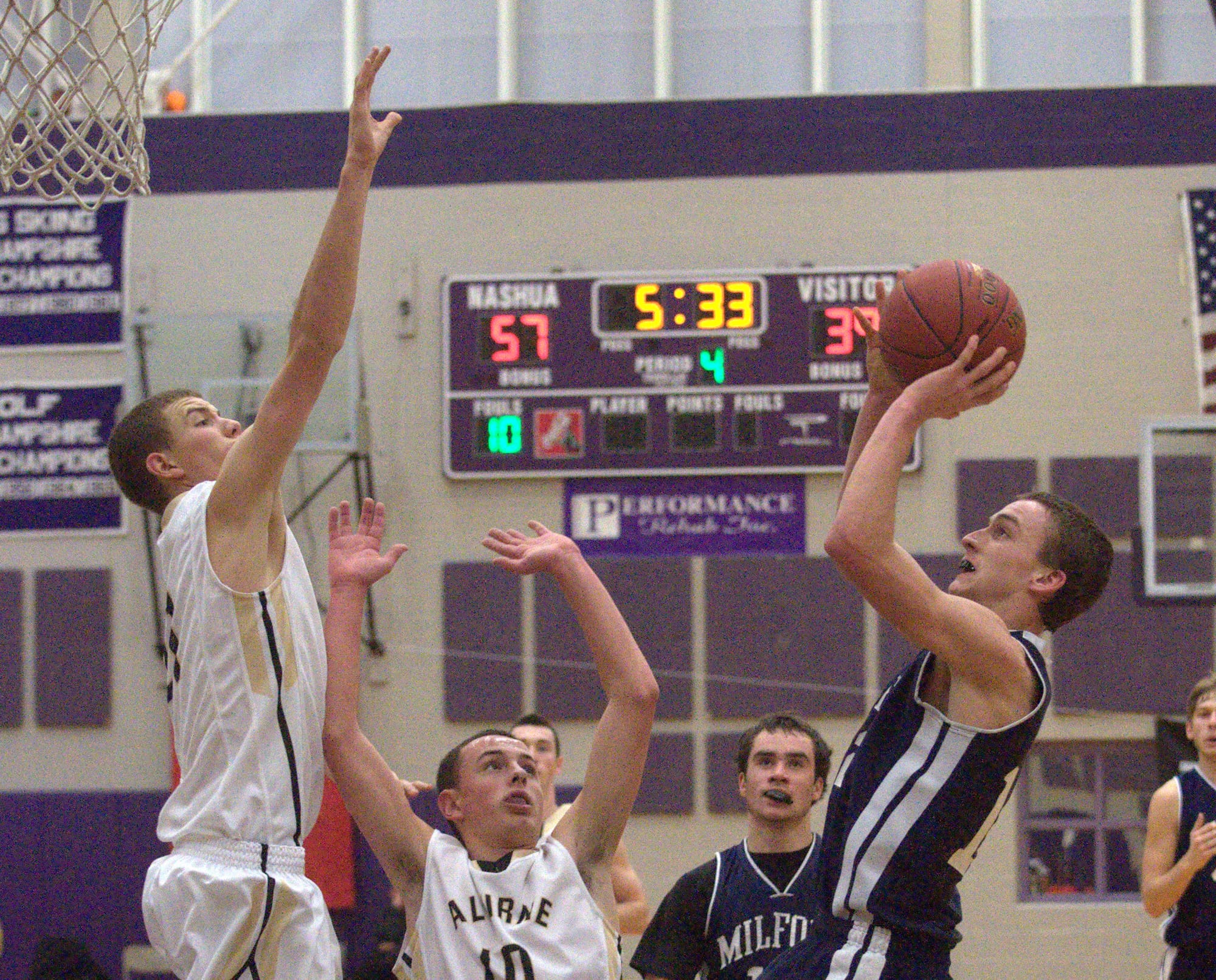 Milford's Mitch Banuskevich tries to take a shot over Alvirne's Tyler Brown, left, and Dan Kingsley during Saturday's game.