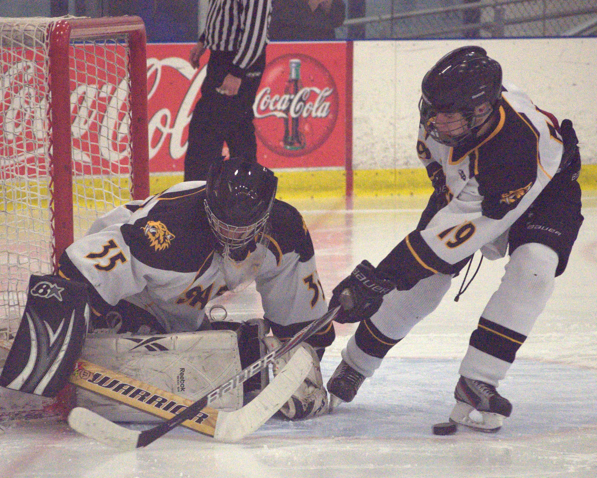 Souhegan's Vincent Silvestri tries to help goalie Ryan Peterson cover up the puck during Wednesday's game. For more photos, go to the Photo Album.