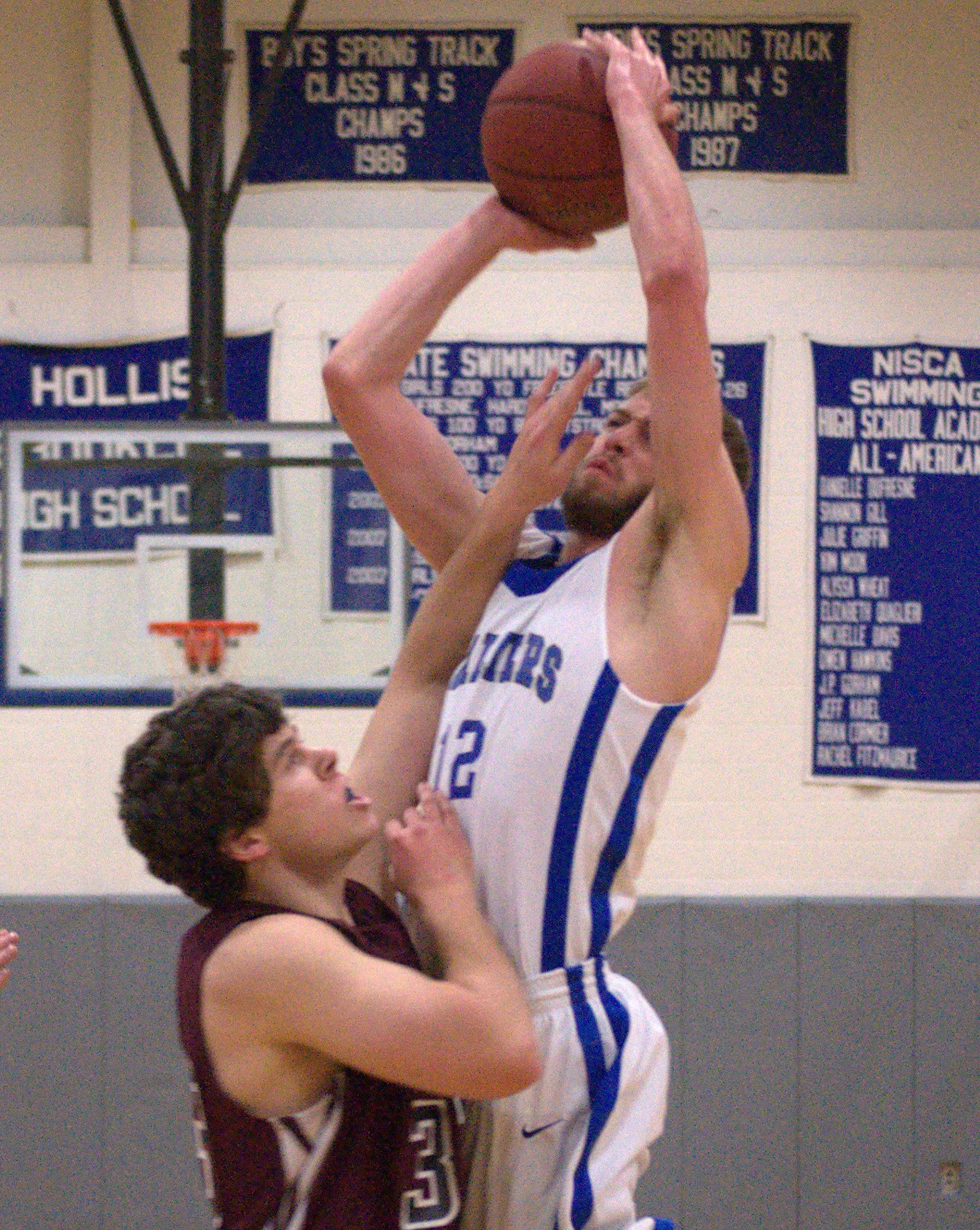 Hollis Brookline's Cole Gallant goes in for a layup as Goffstown's Tyler Barss defends. For more photos, go to the Photo Album.