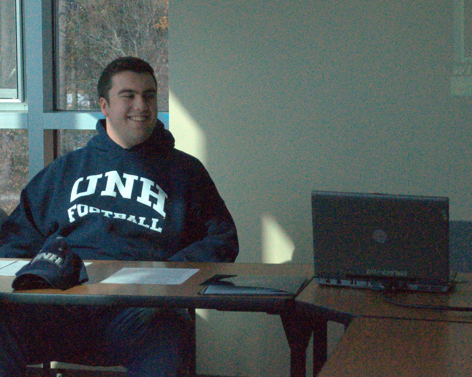Jake Kennedy smiles as he watches a highlight video Wednesday before signing his letter of intent to play football at UNH.