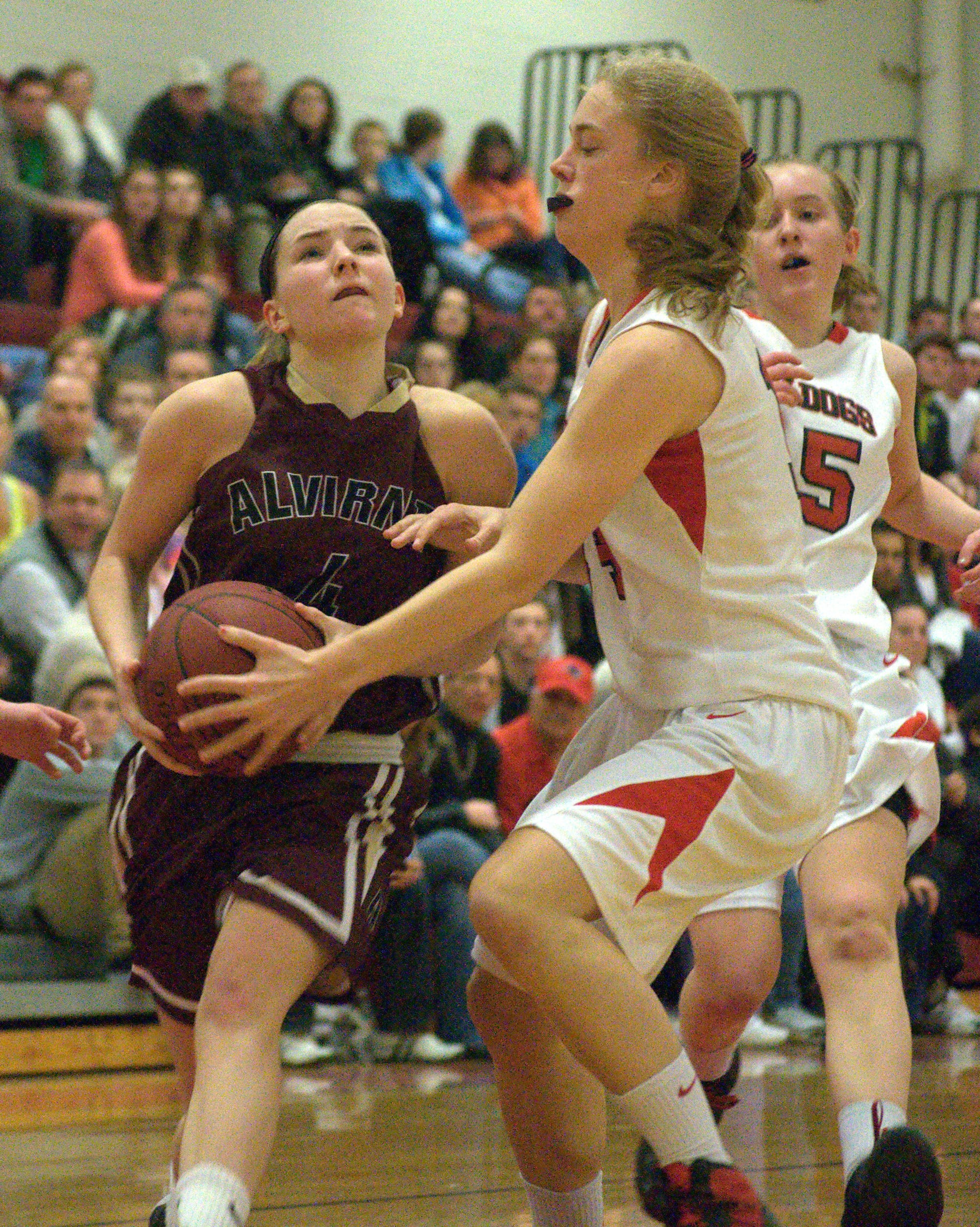 Bedford's Haley Driscoll gets a hand on the ball as Alvirne's Sandi Purcell drives to the basket. For more photos, go to the Photo Album.