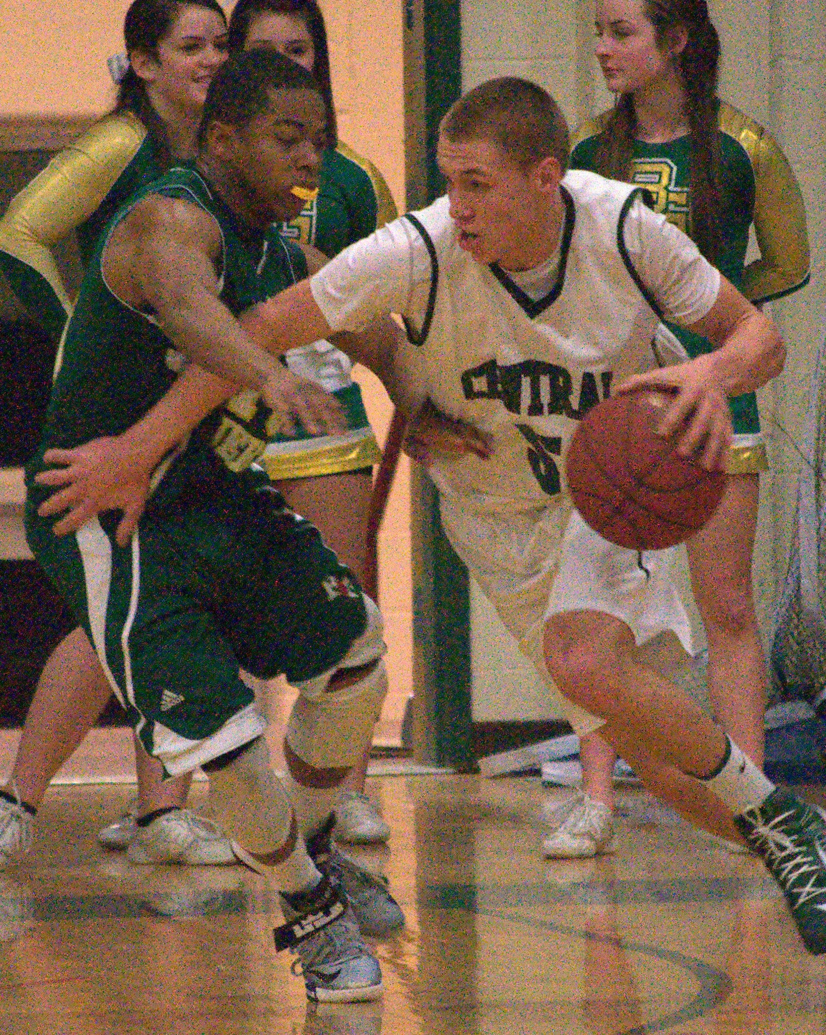 Manchester Central's Troy Pelletier tries to drive to the basket as Bishop Guertin's CJ Boykin defends.