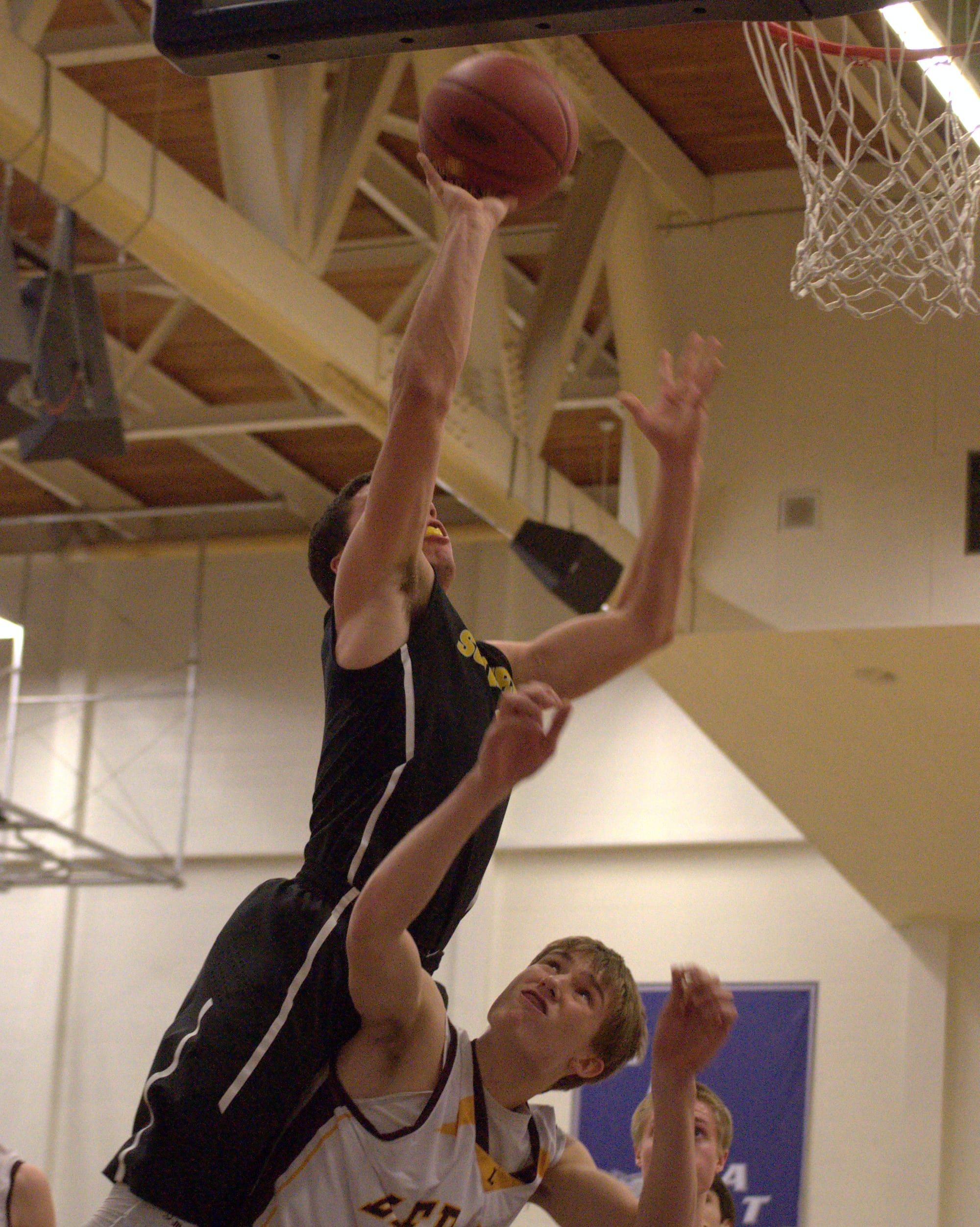 Souhegan's Tyler Ford goes in for a layup over Lebanon's Austin Pelletier during Wednesday's game. For more photos, go to the Photo Album.