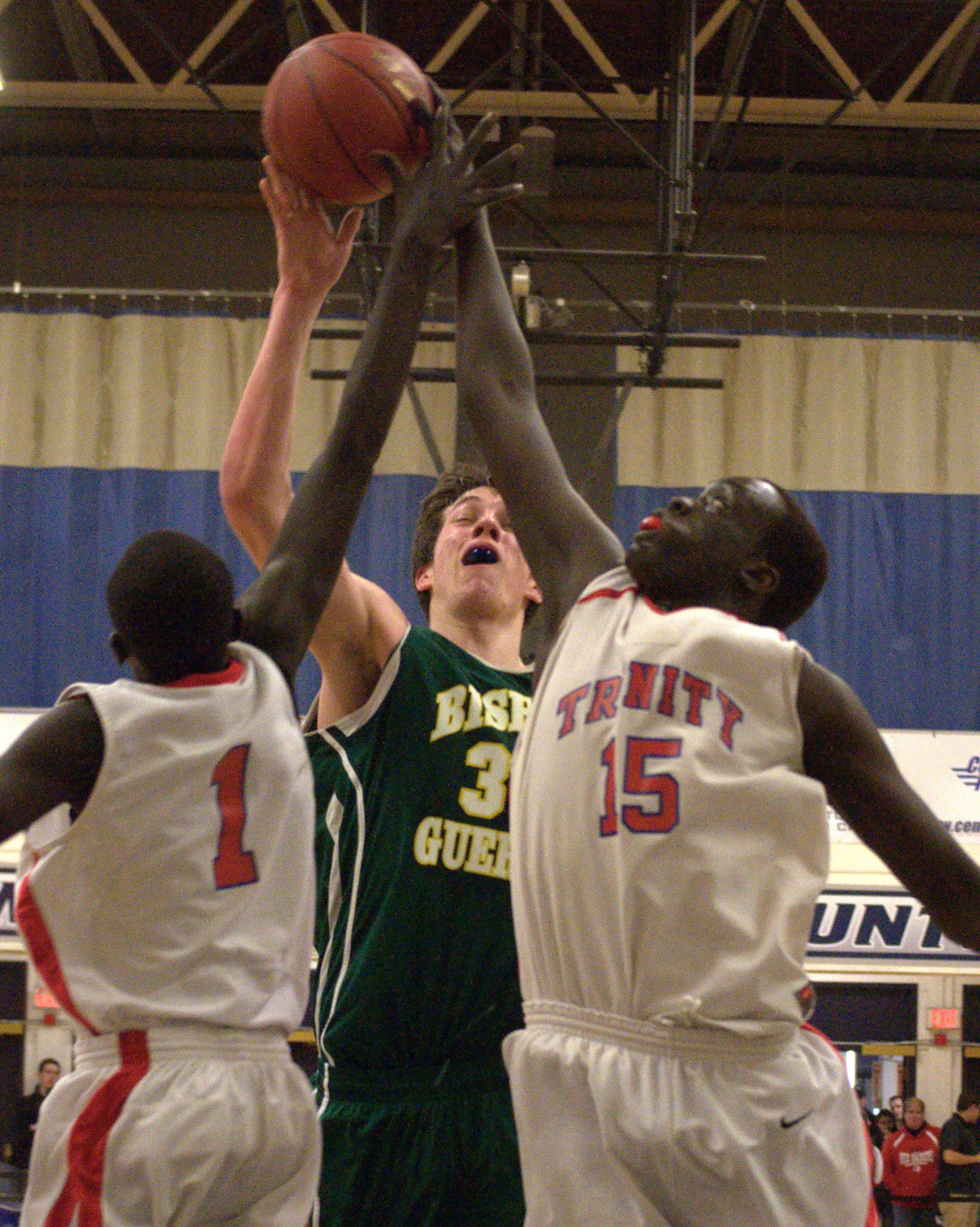 Trinity's Wenjin, left, and Mabor Gabriel team up to block a shot by Bishop Guertin's Jeff Lunn.