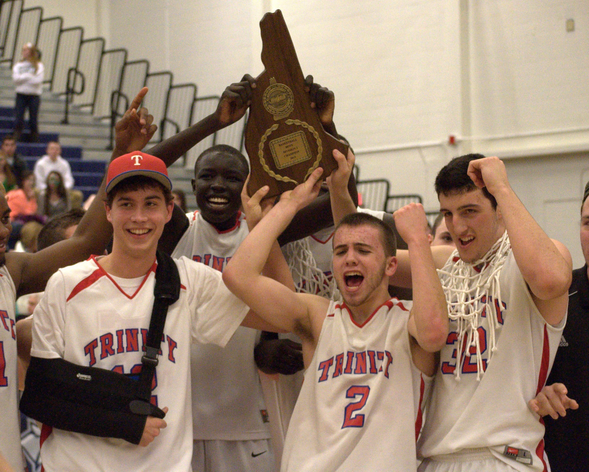 Trinity players celebrate after winning the Division I boys basketball championship. For more photos, go to the Photo Album.