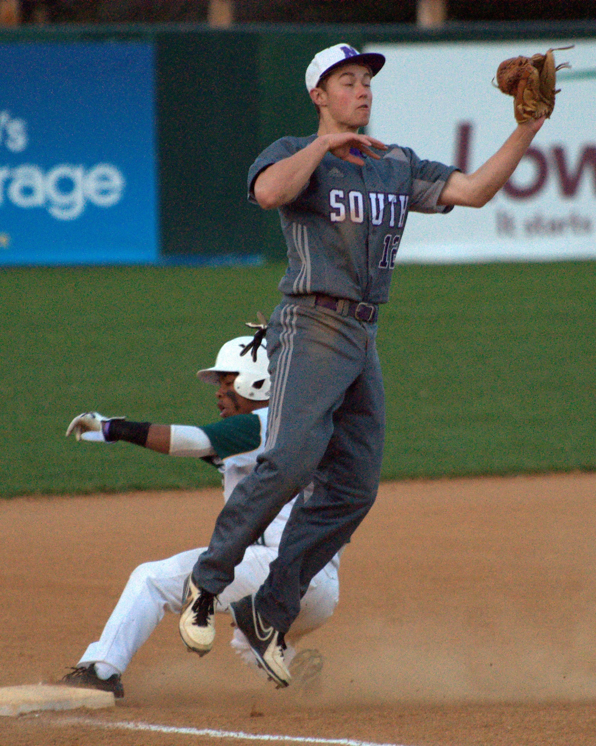 Nashua South's Matt Byers fields a throw as Bishop Guertin's CJ Boykin slides into third.