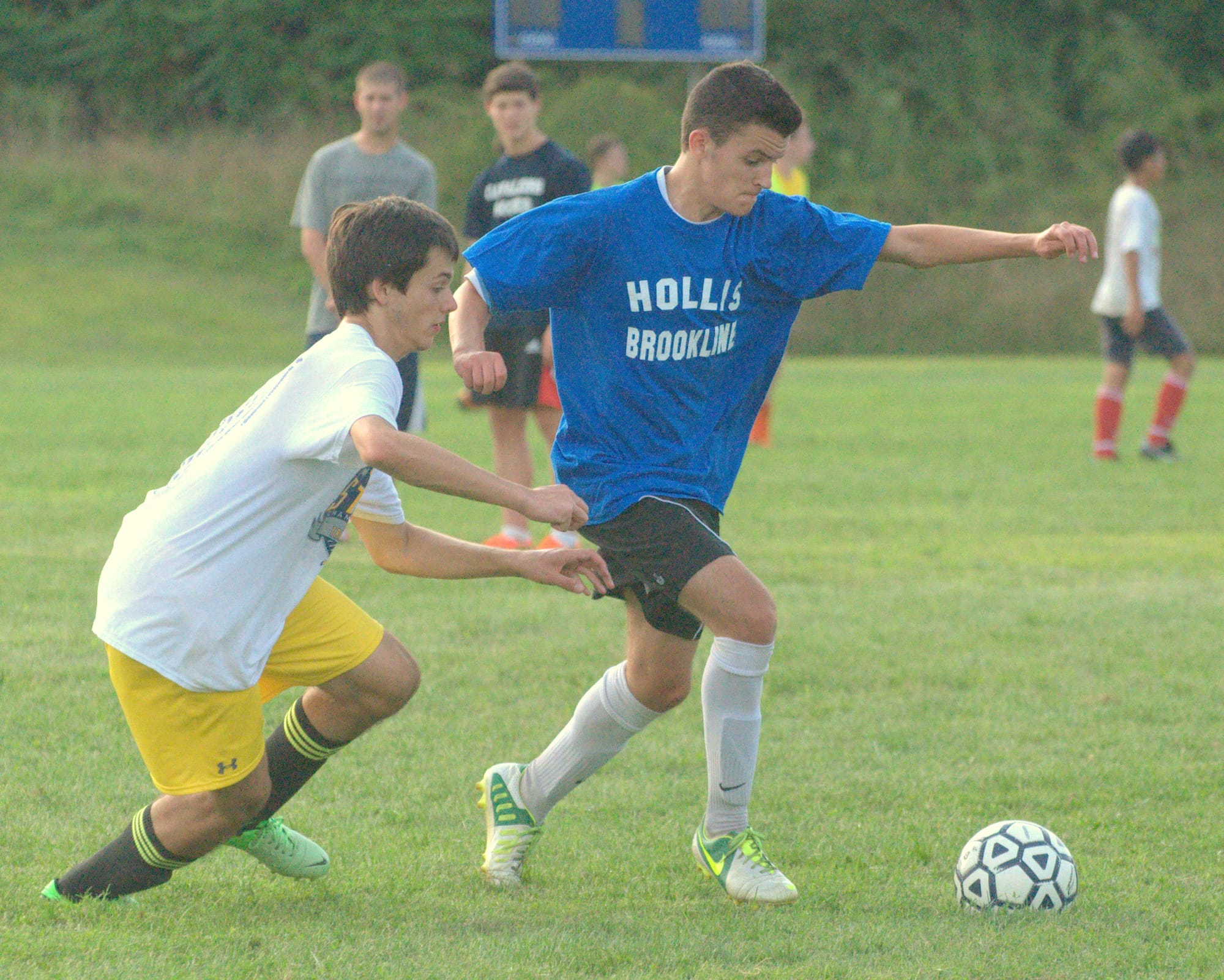 Evan Porter, left, and Matt Claire battle for the ball Monday during the first day of practice for the Hollis Brookline boys soccer team.