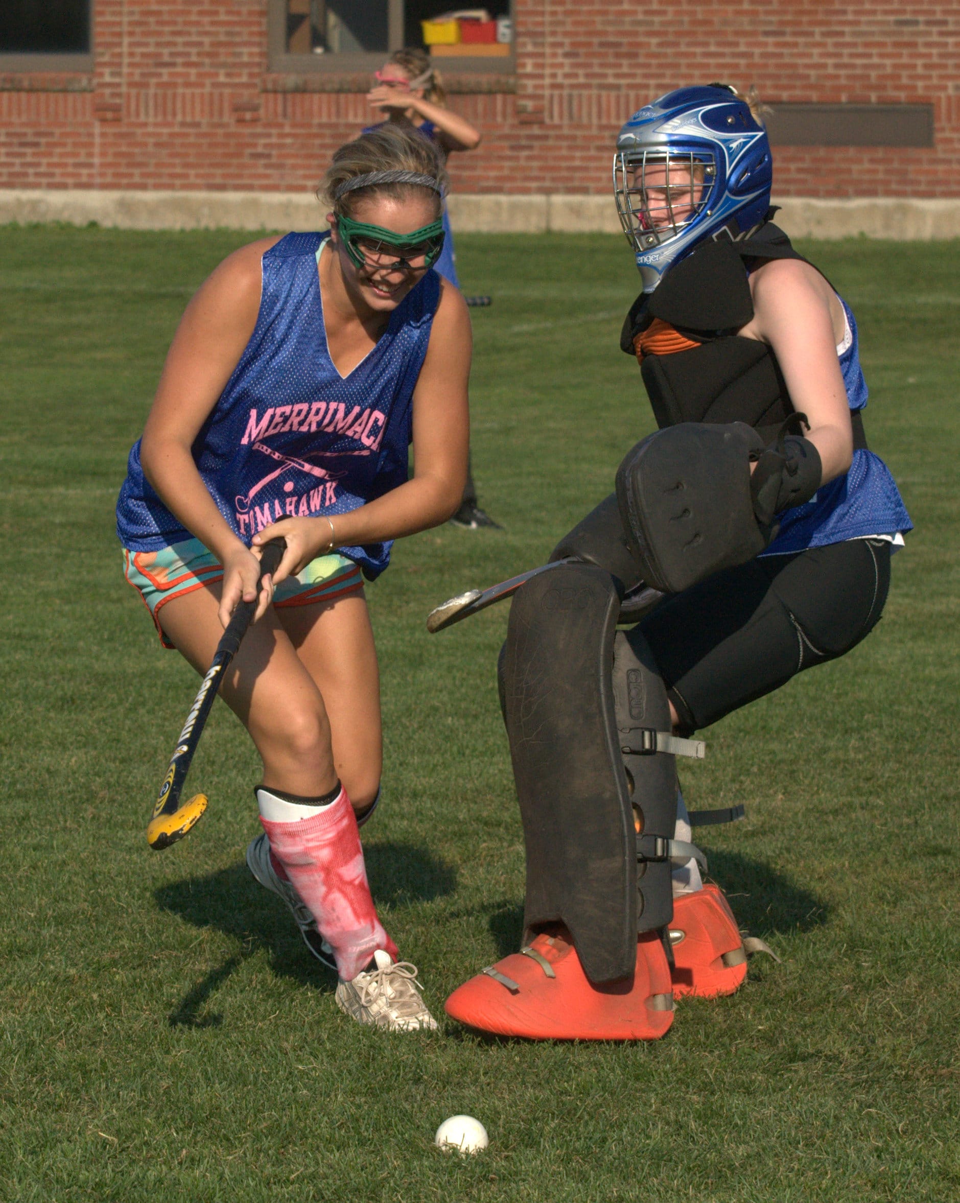 Merrimack goalie Mackensie Hennas tries to slow down Julia Perry during field hockey practice last week.