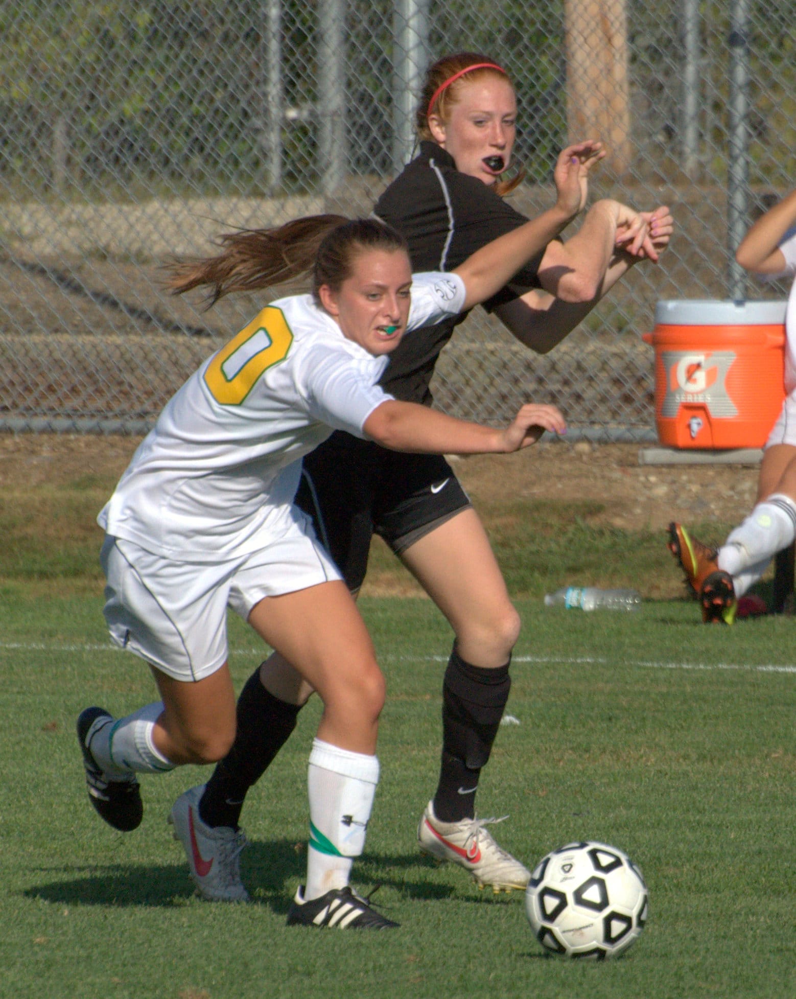 Bedford's Christina Campbell and Bishop Guertin's Jamie Sherburne get tangled up going for a loose ball. For more photos, go to the Photo Album.