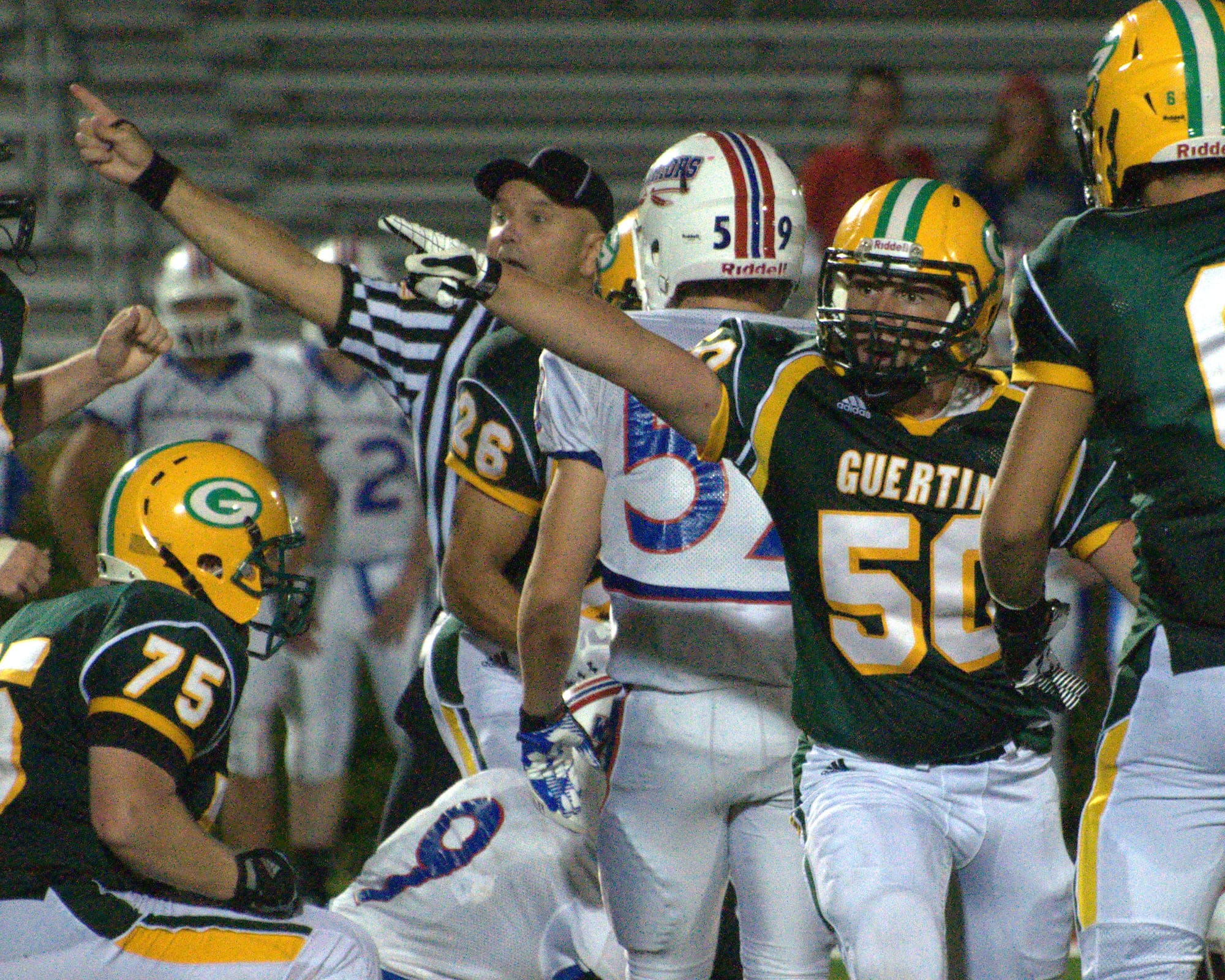Bishop Guertin's Slade Sousa helps an official make a call after the Cardinals recovered a fumble during Saturday's game against Winnacunnet.