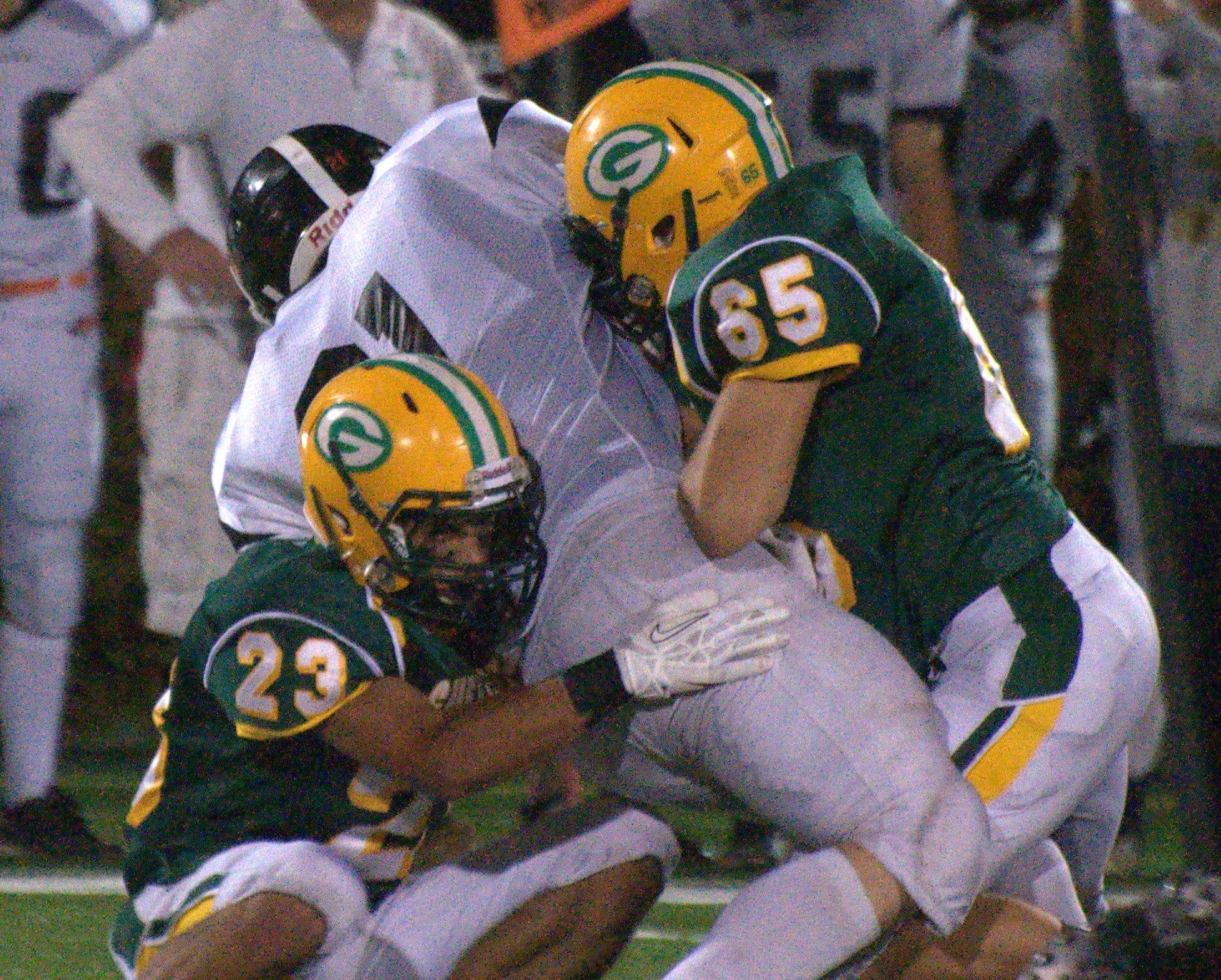 Bishop Guertin's Kelvin Rivera, left, and Ryan Monteer combine to make a stop on Keene's Alex Parenteau during Saturday's game.