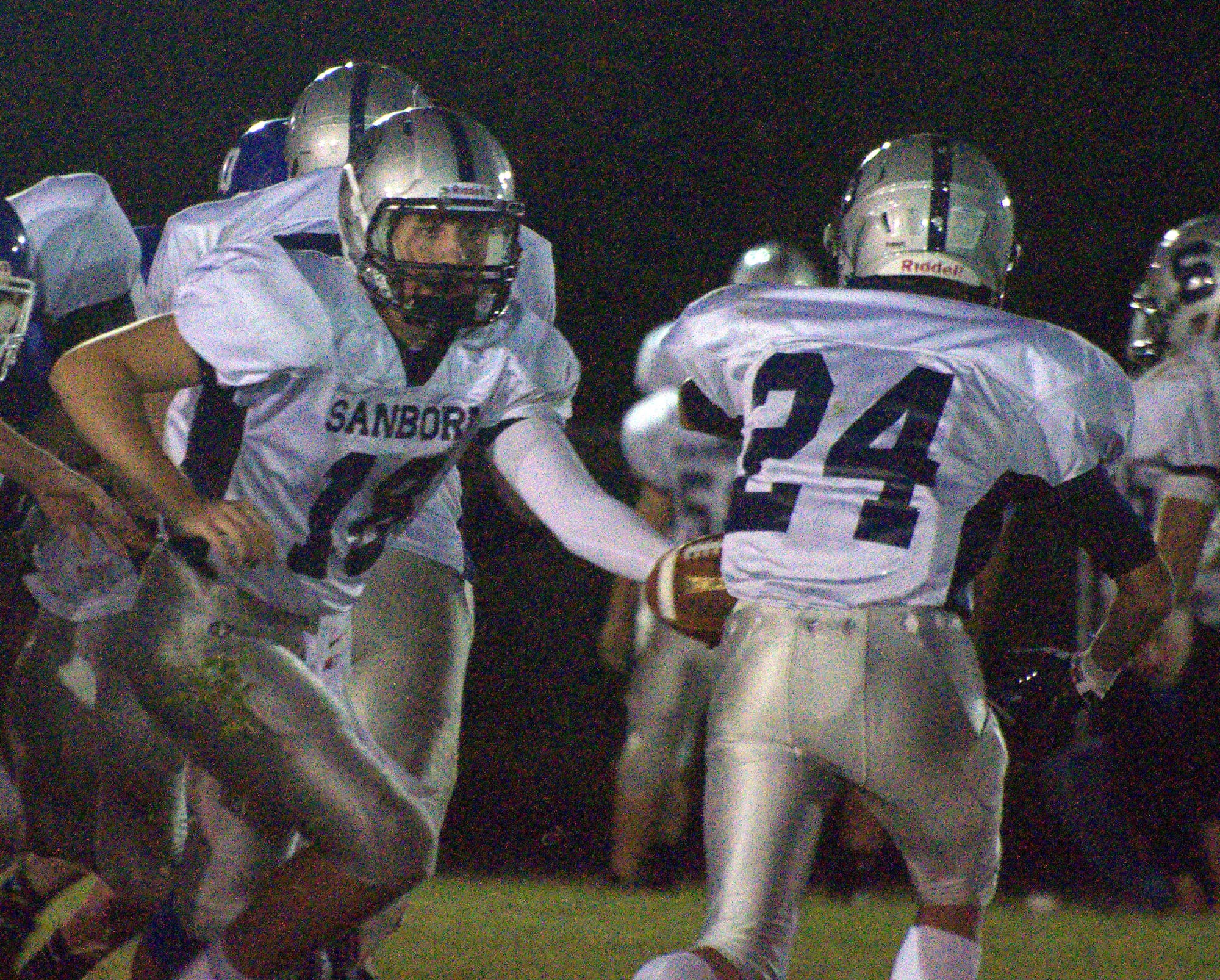 Sanborn quarterback John Morris hands off to Kyle Olsen during Saturday's game against Hollis Brookline.