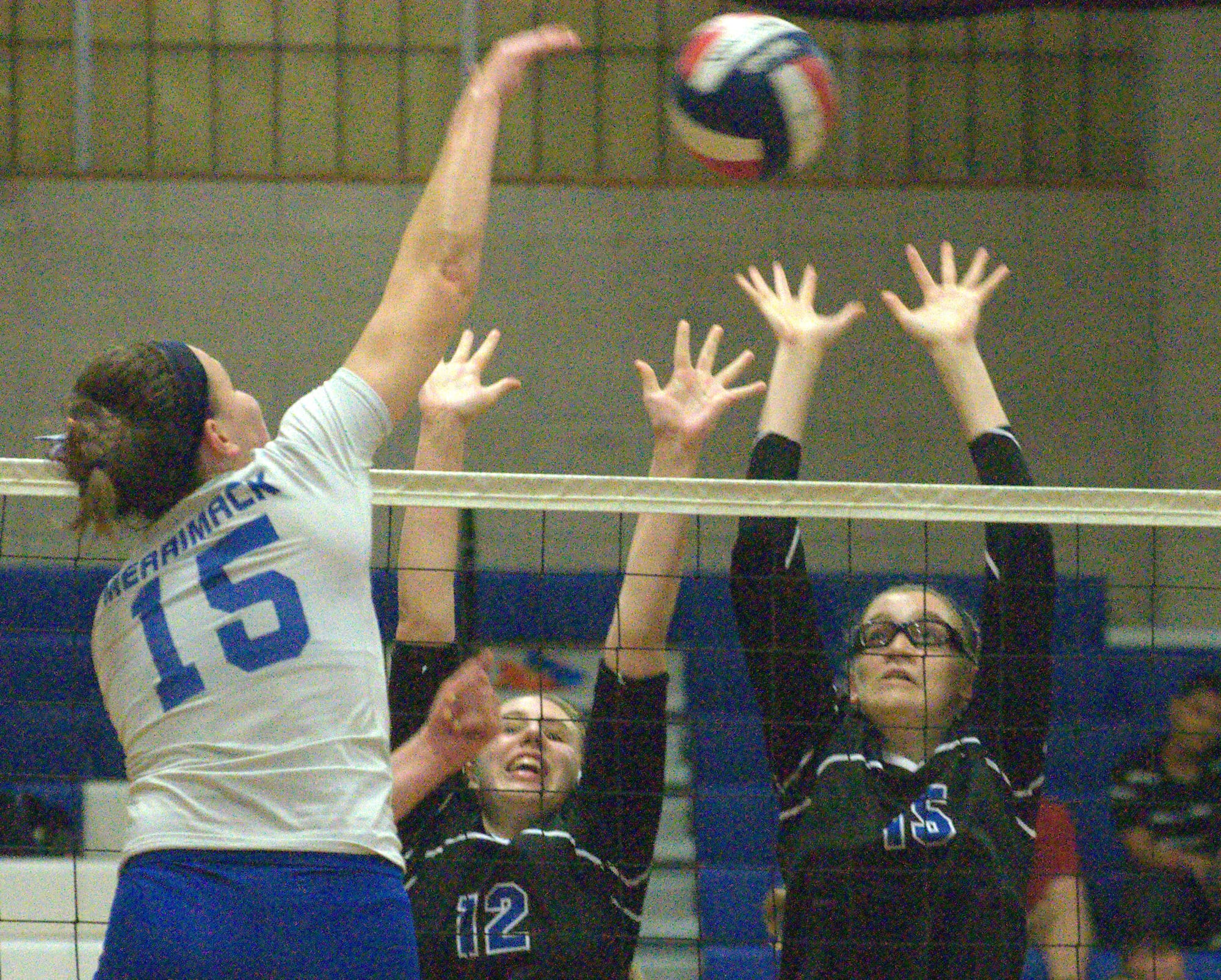 Hollis Brookline's Emily Cook, right, and Kayla Barron try to block Merrimack's Jen Coffey during Monday's match. For more photos, go to the Photo Album.