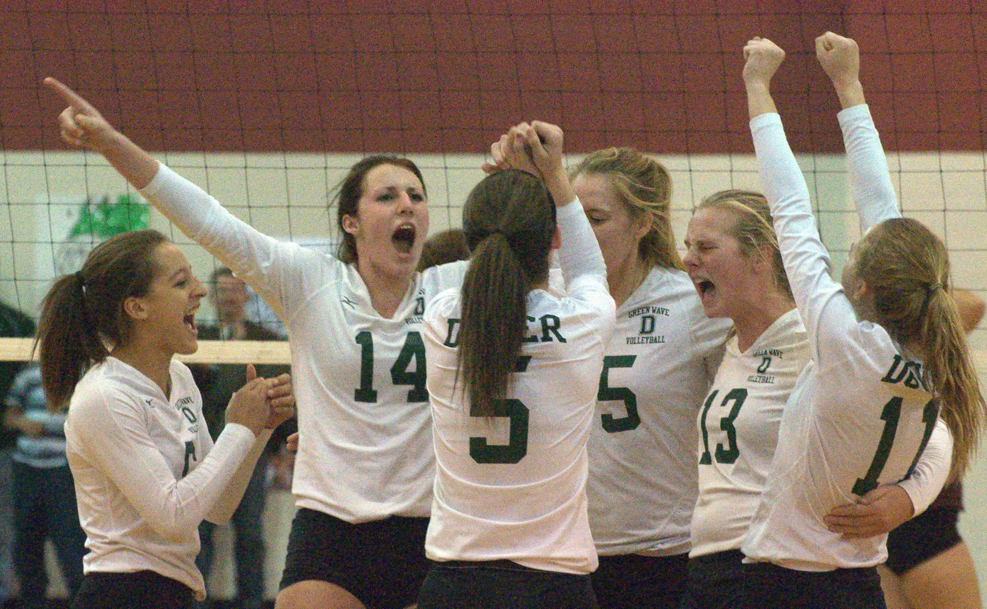 The Dover girls volleyball team celebrates its semifinal win over Alvirne.