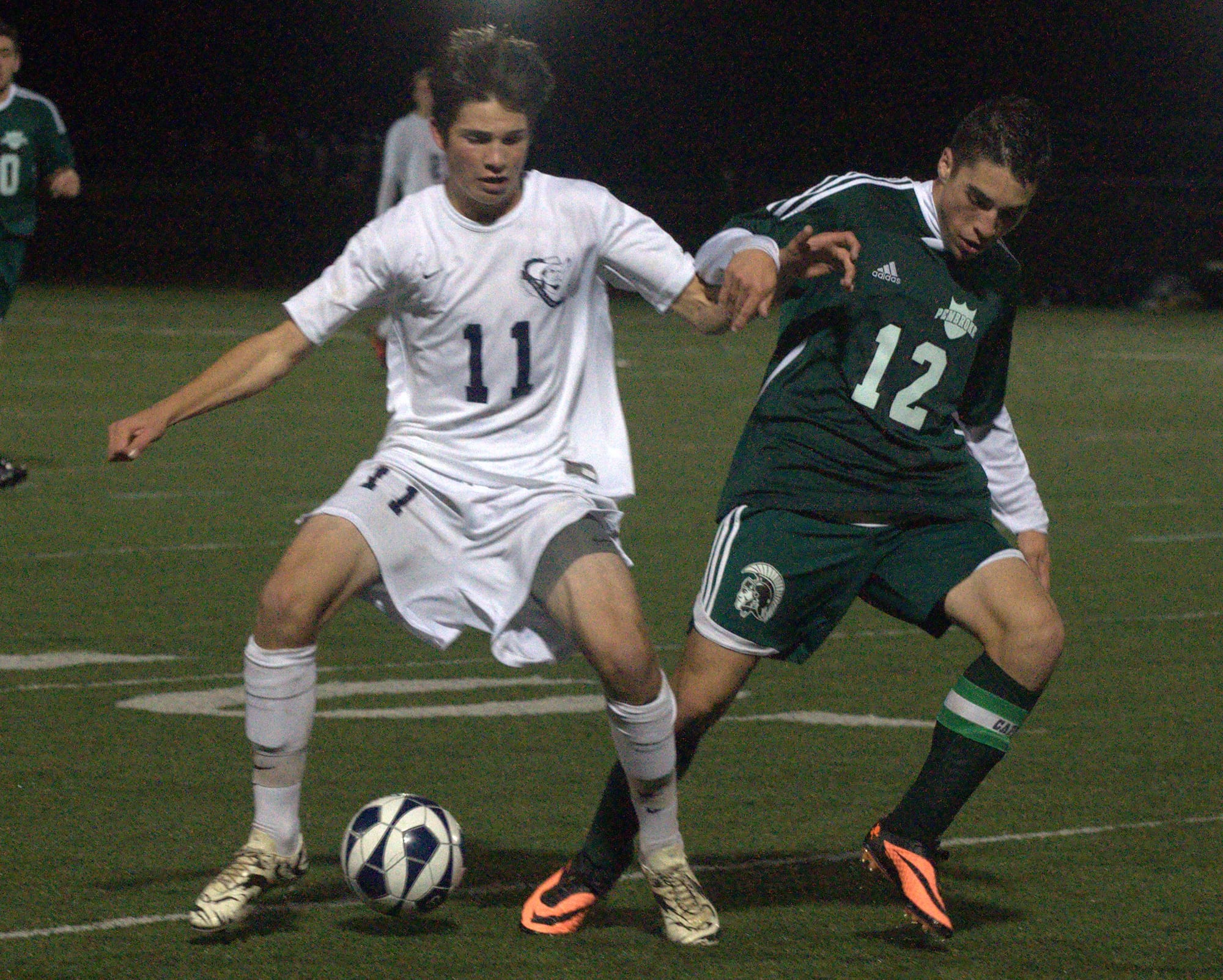 Hollis Brookline's Nate Rogers and Pembroke's Brendan Pettigrew battle for the ball during Thursday's semifinal.