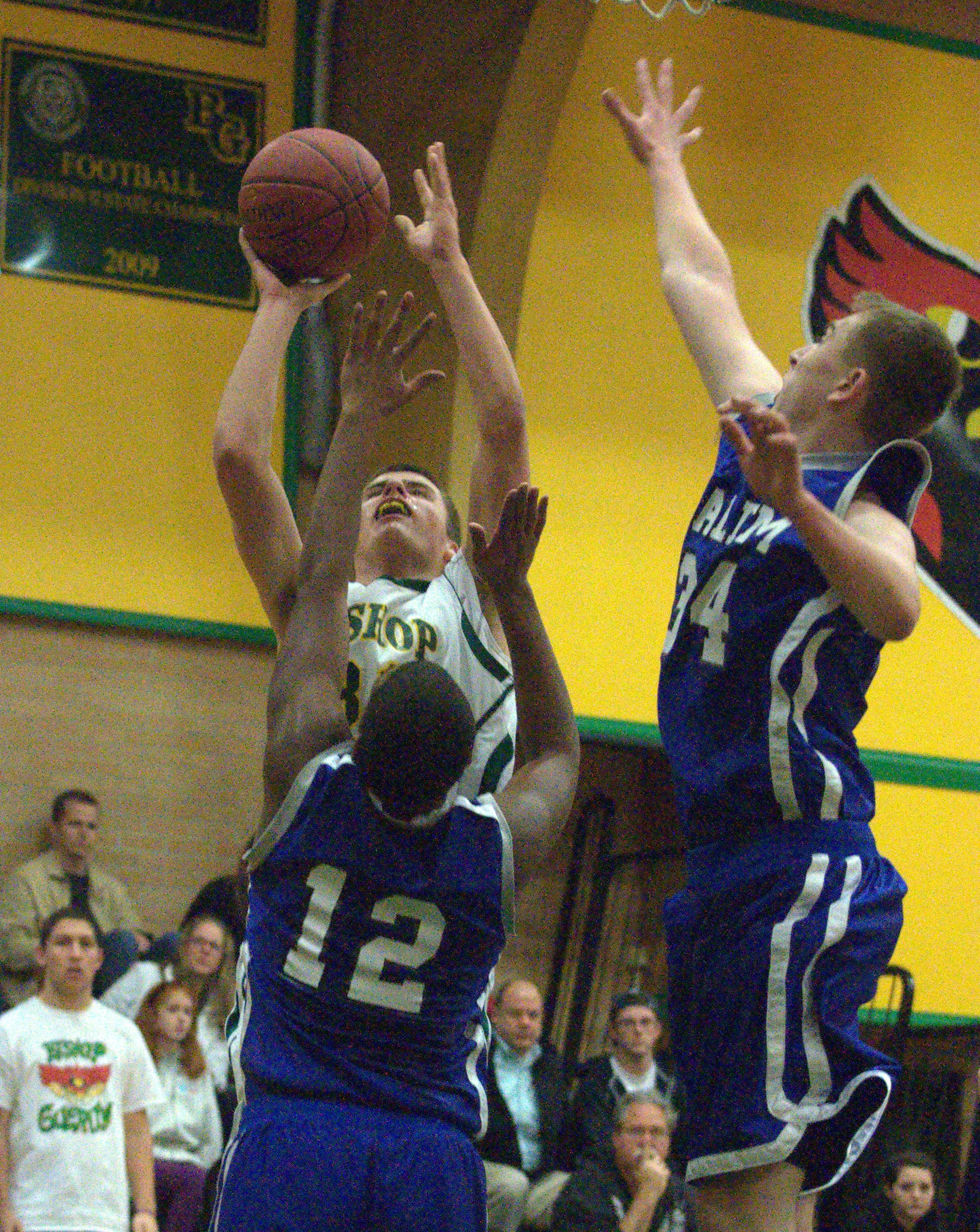 Bishop Guertin's Kyle Gavin puts up a shot as Salem's Michael Felix, left, and Timothy Dodier try to defend during Thursday's game.