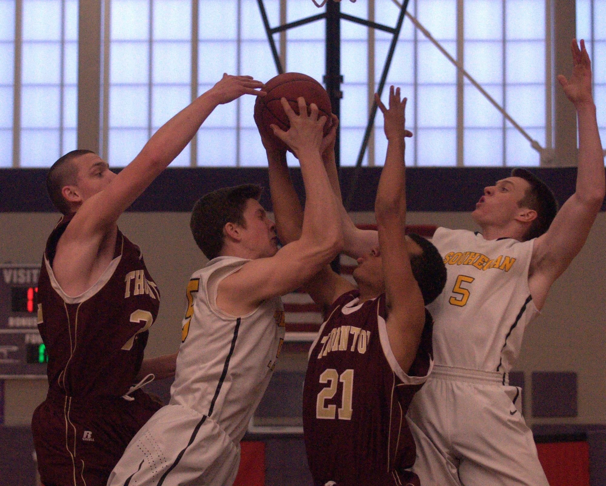 Thornton players Quinn Richardson-Newton, left, and Corey Hart battle for a rebound with Souhegan's Isaac Nevrla, left, and Ben DeForest during Saturday's game.