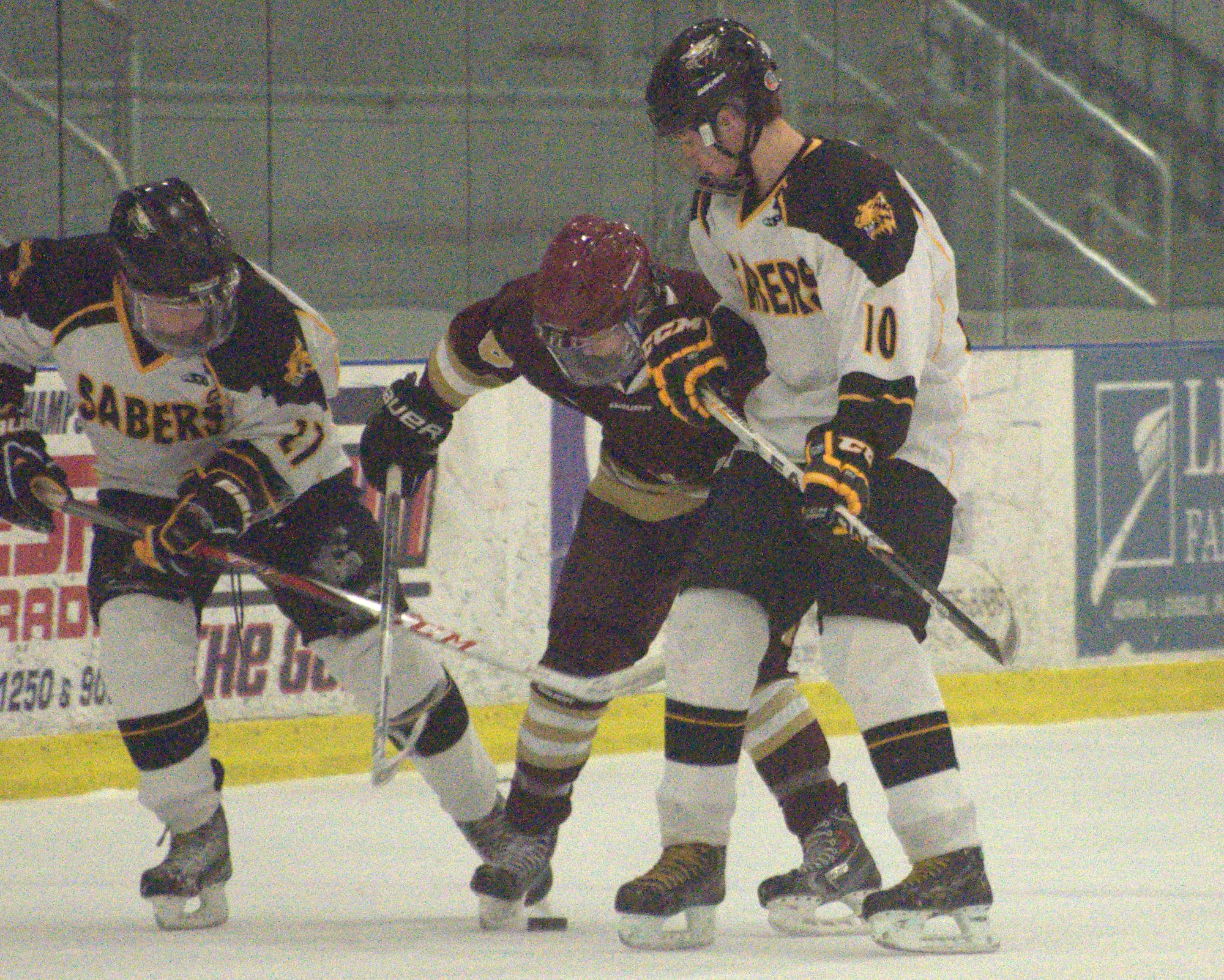 Portsmouth's Jack Alden battles for the puck with Souhegan's Alexander Maresco, left, and Kevin O'Brien during Saturday's game. For more photos, go to the Photo Album.