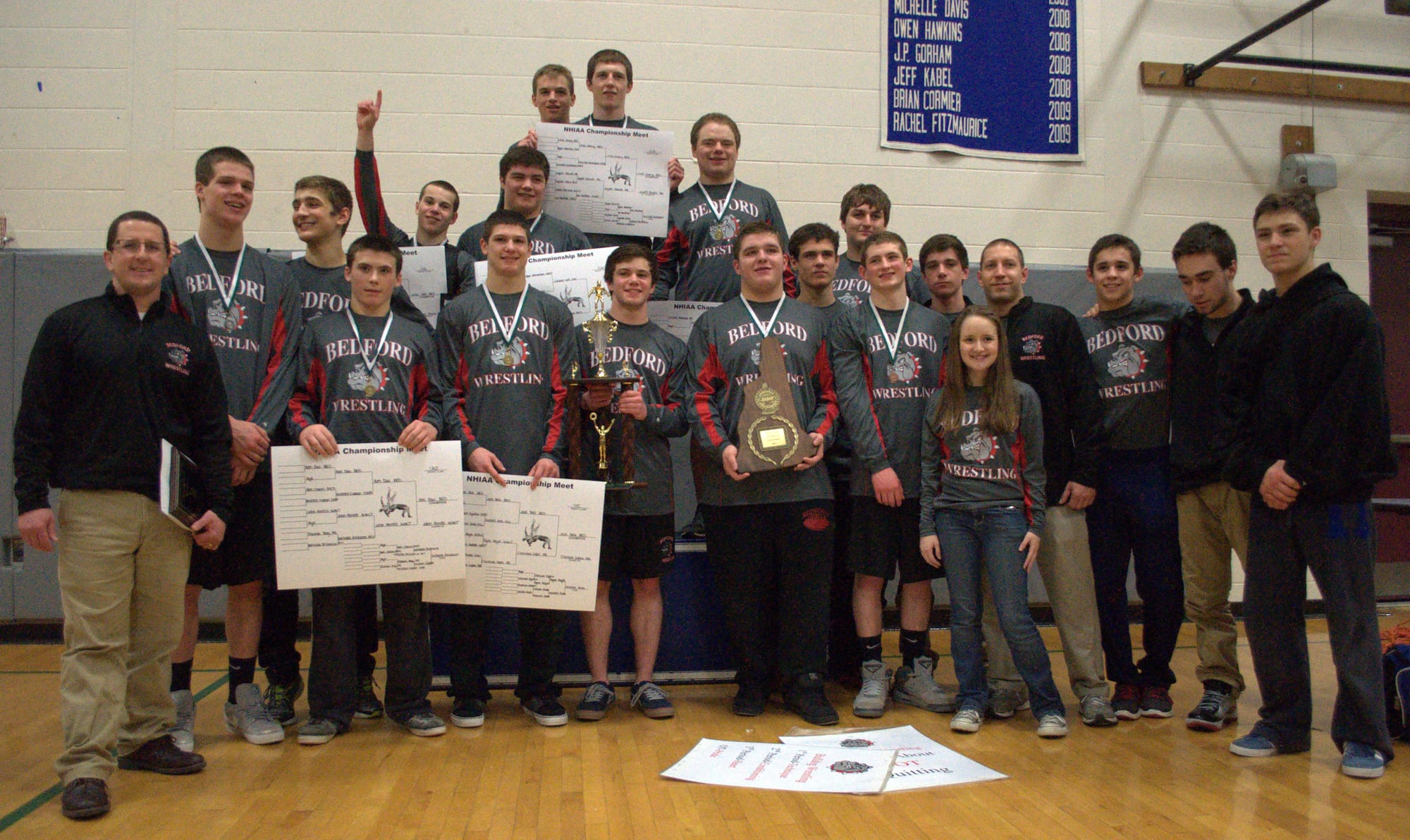 The Bedford High School wrestling team poses with the Division II championship plaque.