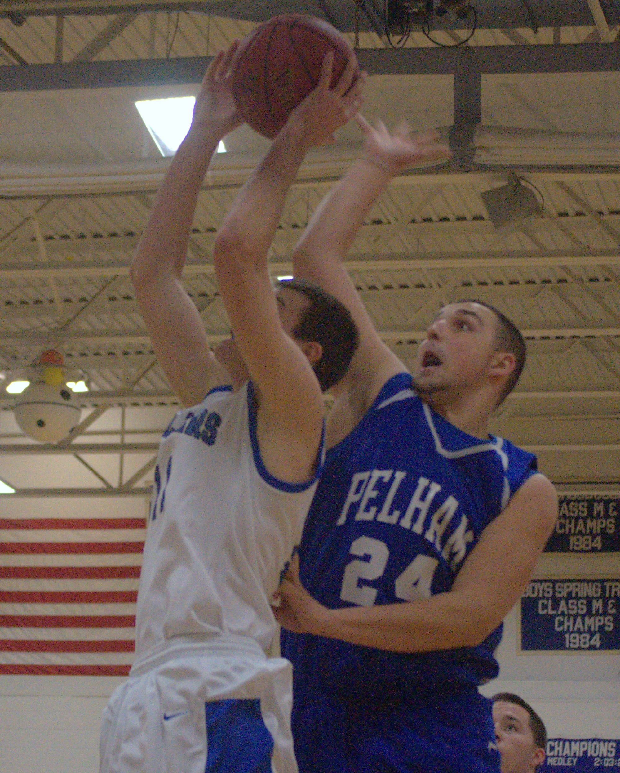 Pelham's Keith Brown gets ready to block a shot by Hollis Brookline's Logan Blake during Monday's game.