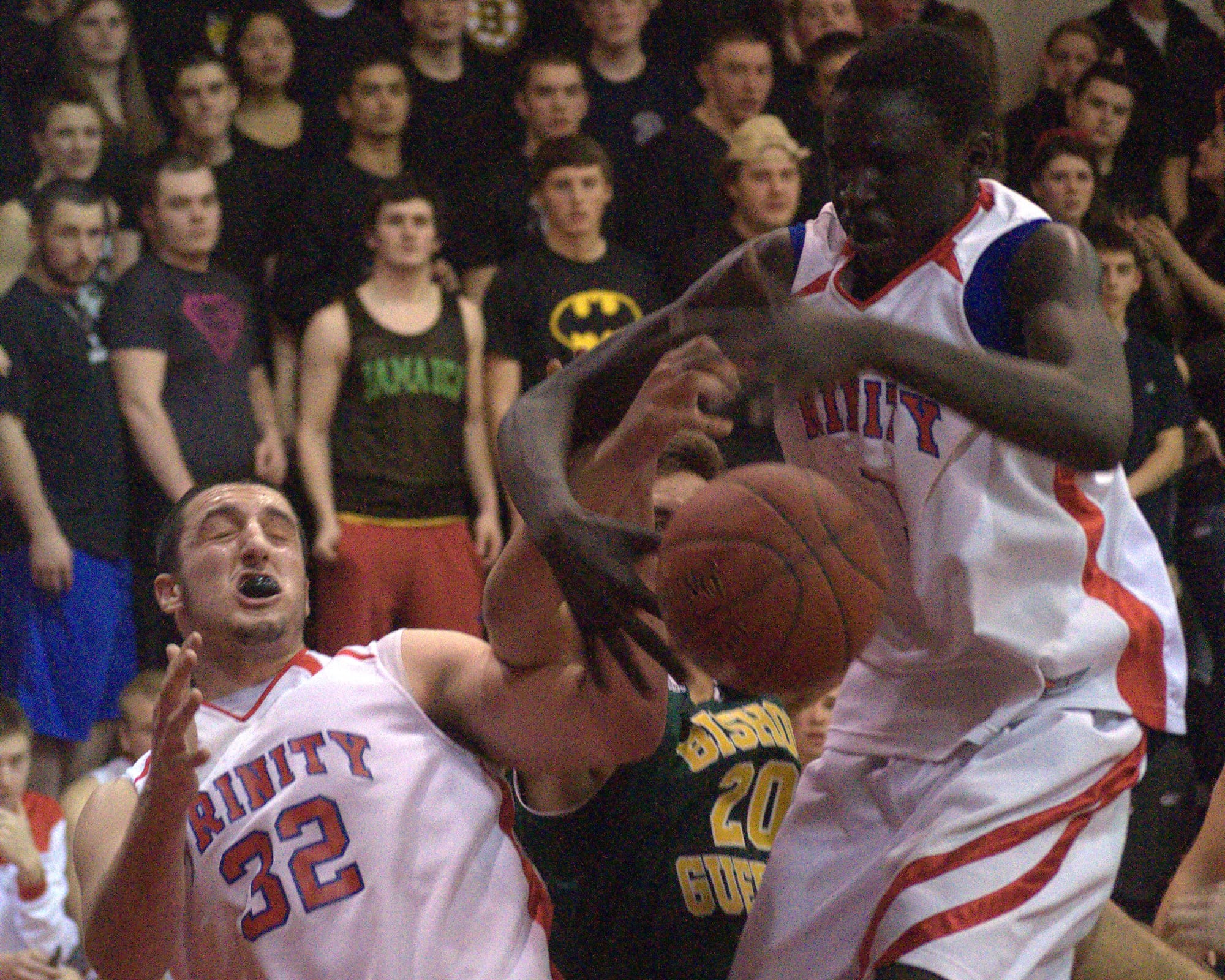 Trinity's Carmen Giampetruzzi, left, and Wenyin Gabriel battle for a rebound with Bishop Guertin's Costas Niarhos during Friday's game.