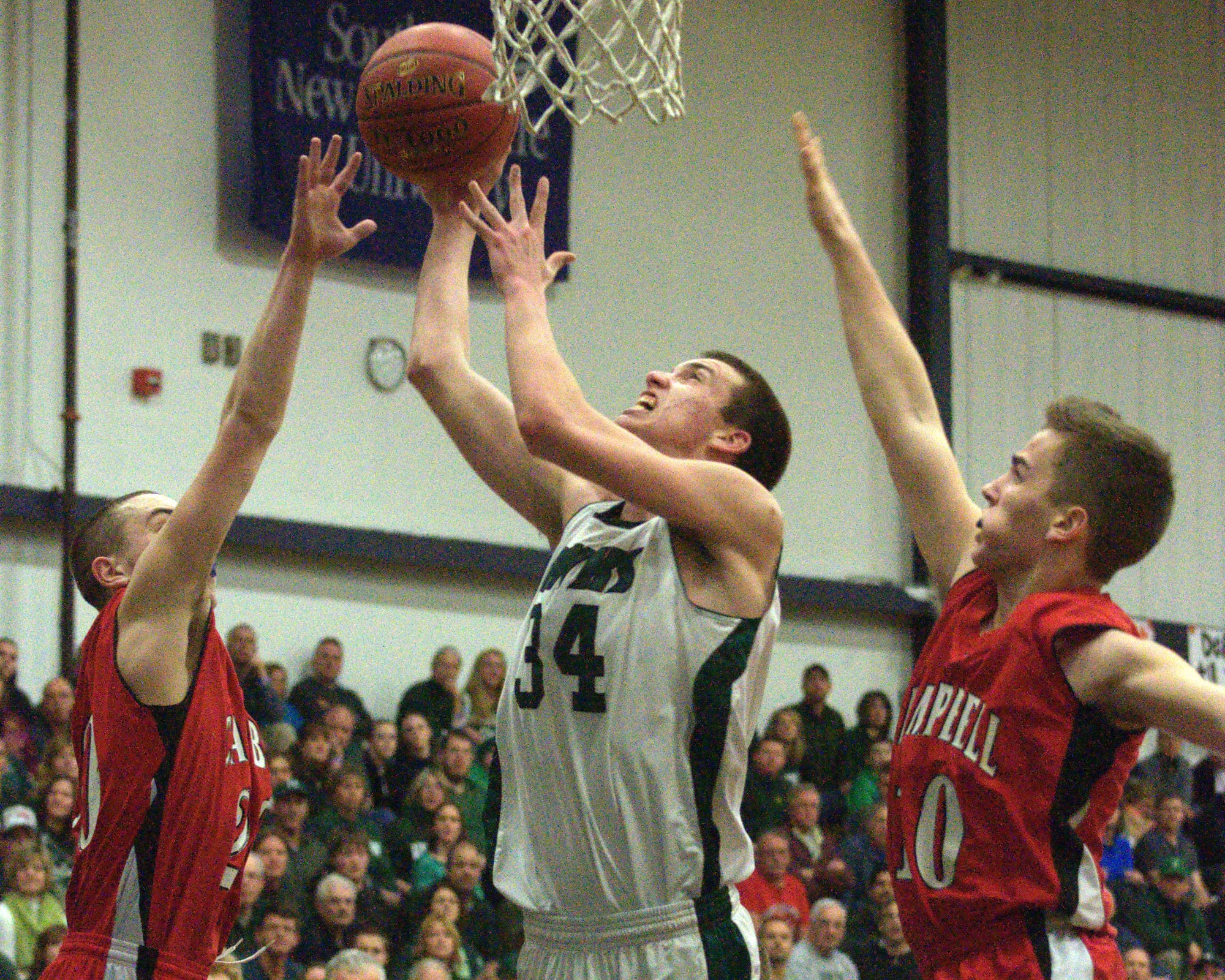 Hopkinton's Gave Nichols goes in for a layup as Campbell's Andrew Smarse, left, and Kyle Manning