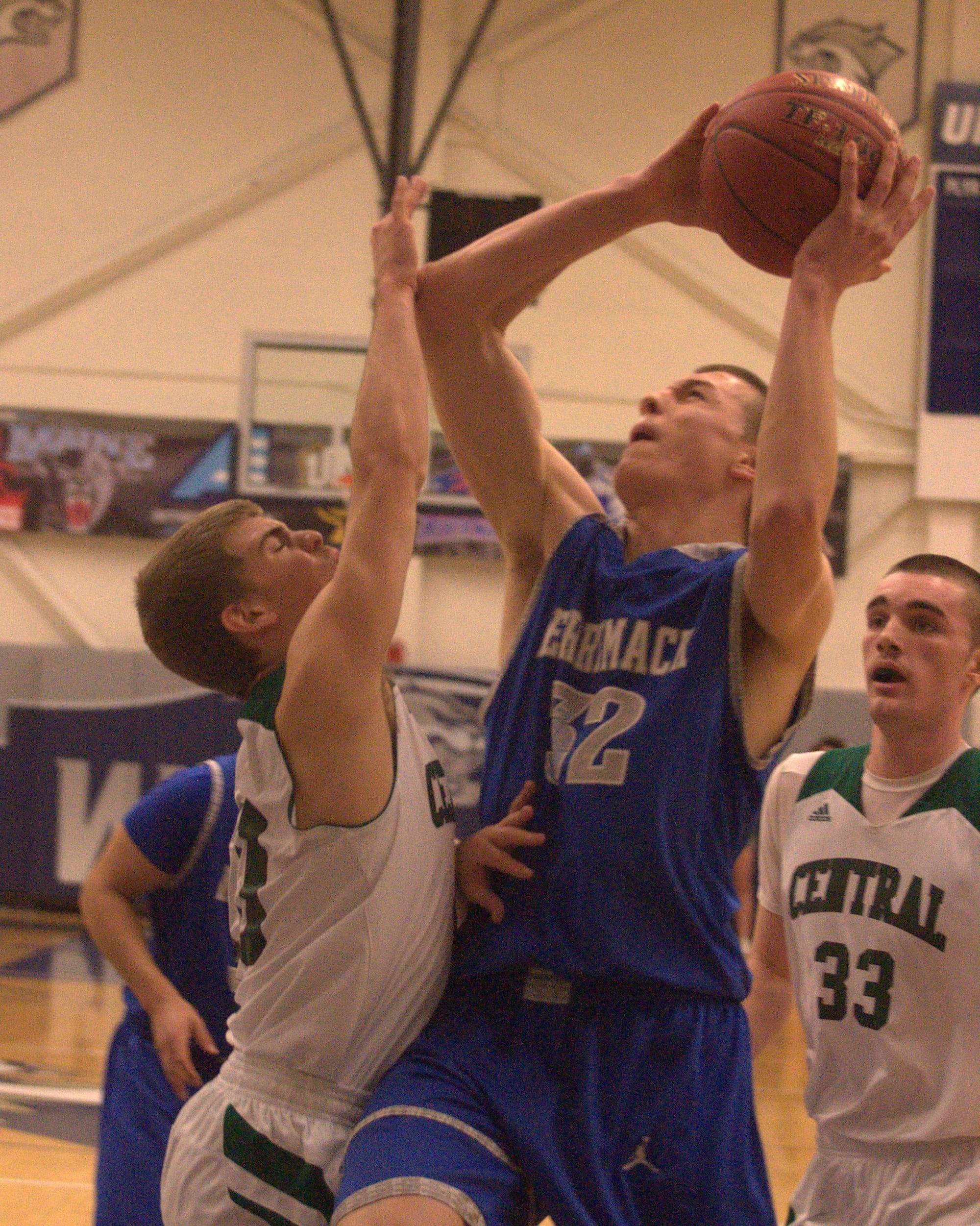 Manchester Central's Dawson Dickson tries to slow down Merrimack's Eric Gendron as he puts up a shot.