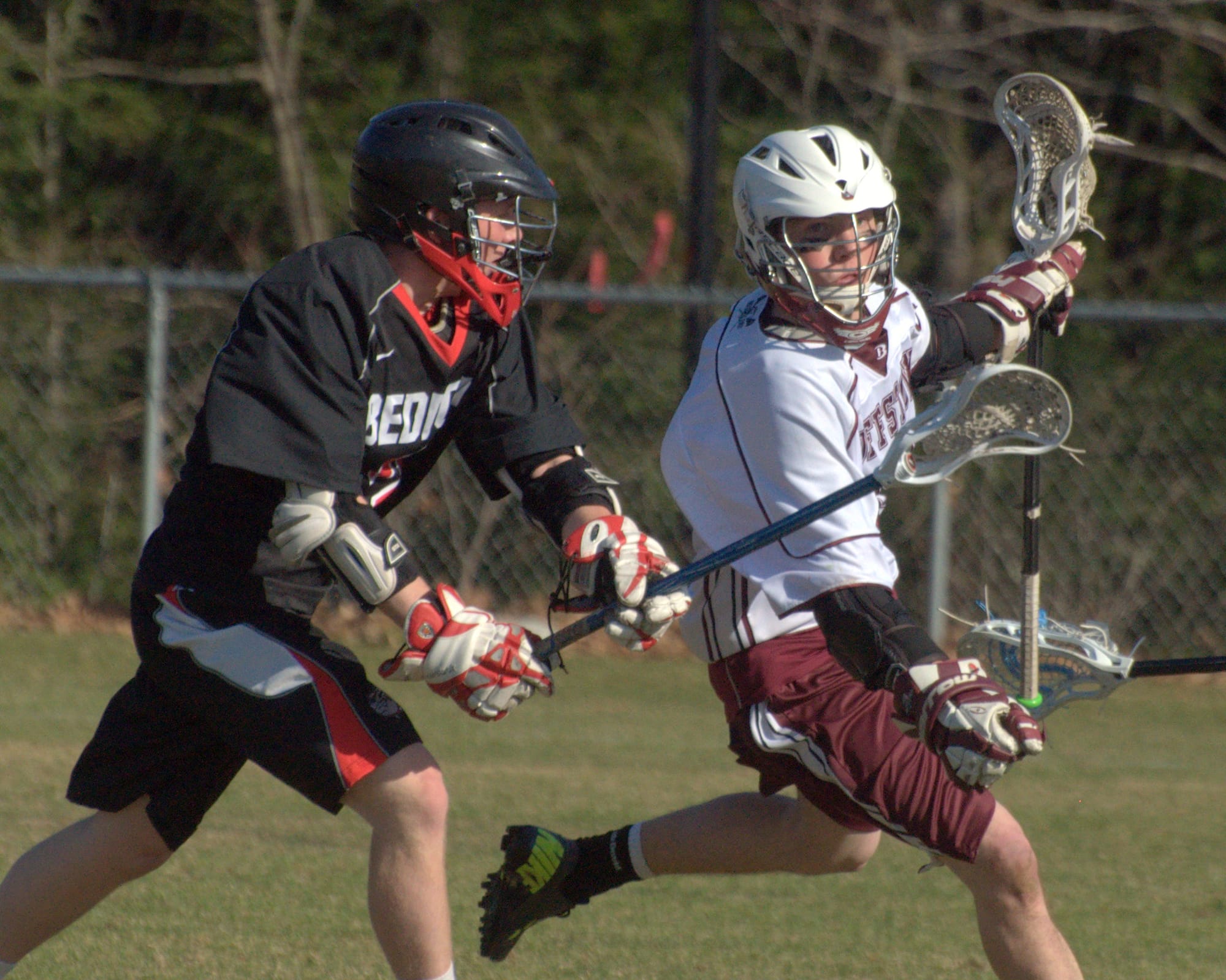 Bedford's Patrick Simpson chases after Goffstown's Jack Carney during Monday's game.