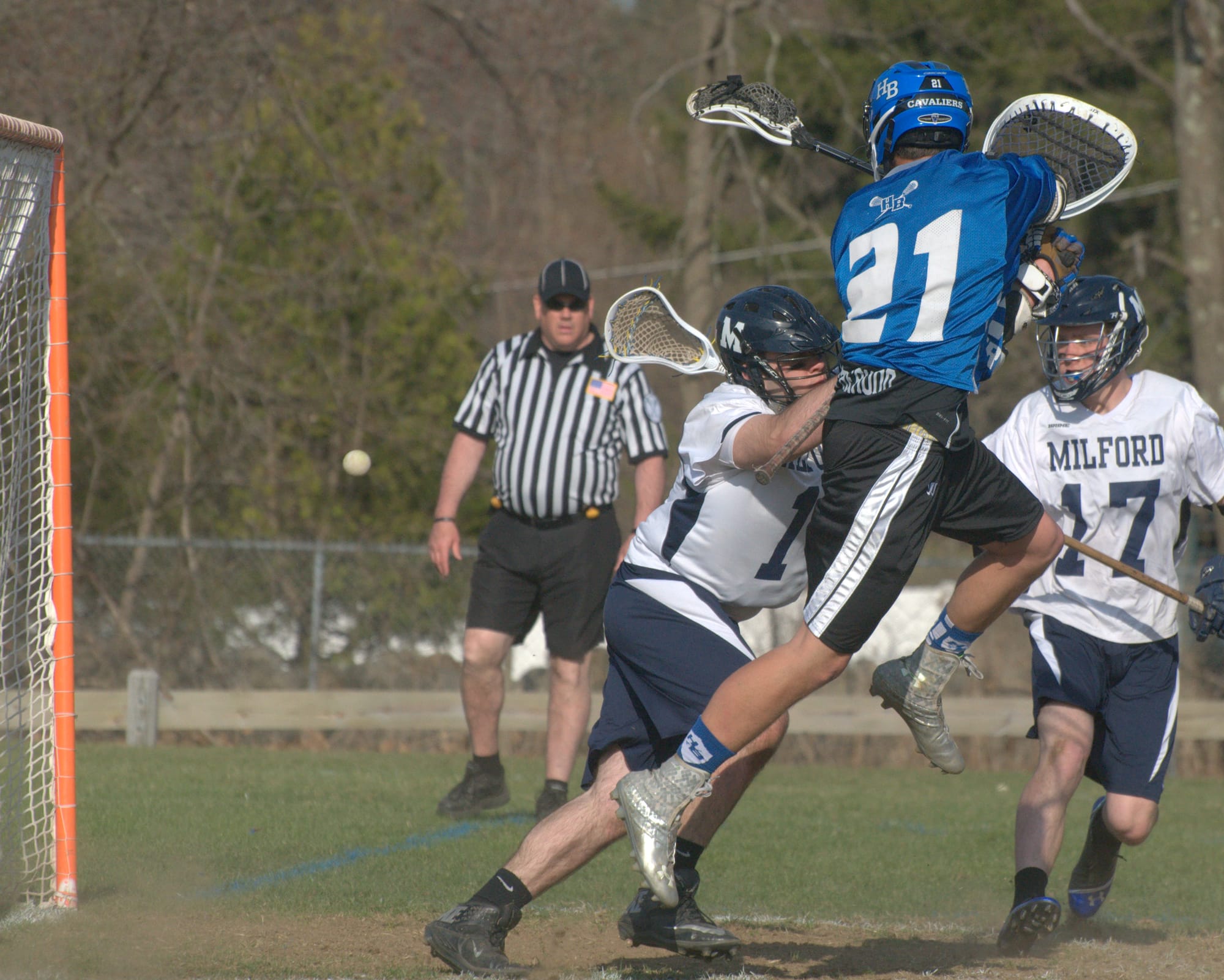 Hollis Brookline's Ryan Papineau takes to the air to score a goal against Milford's Adam Audet.