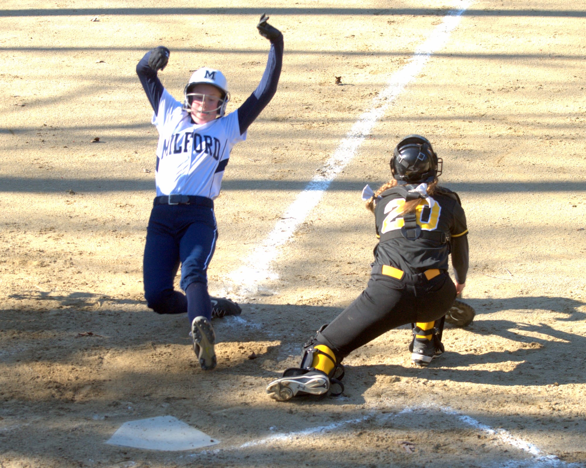 Milford's Carley Holtshouser slides into home before Souhegan's Lauren McCormick can make the tag during Thursday's game.