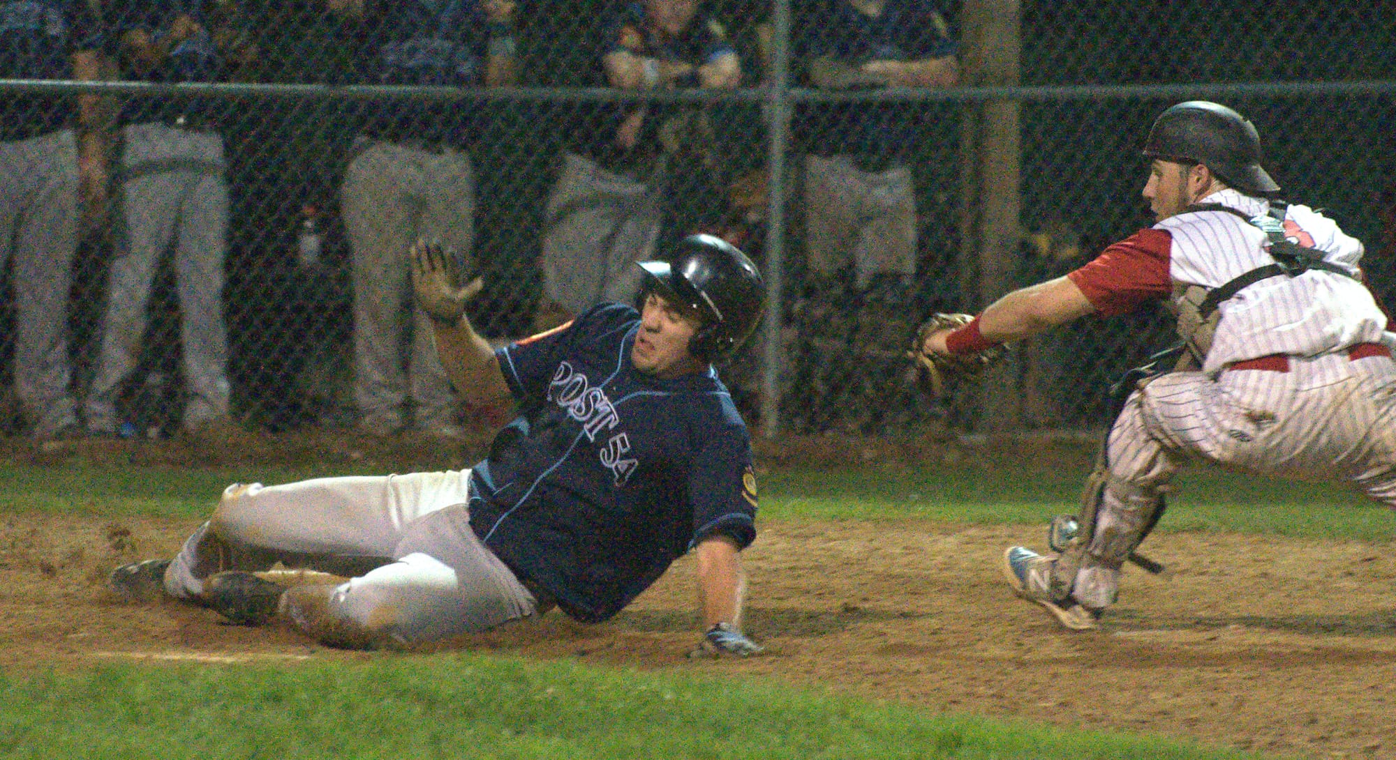 Bedford's Michael Kernan slides safely past Concord catcher Chris Fournier during Thursday's game.