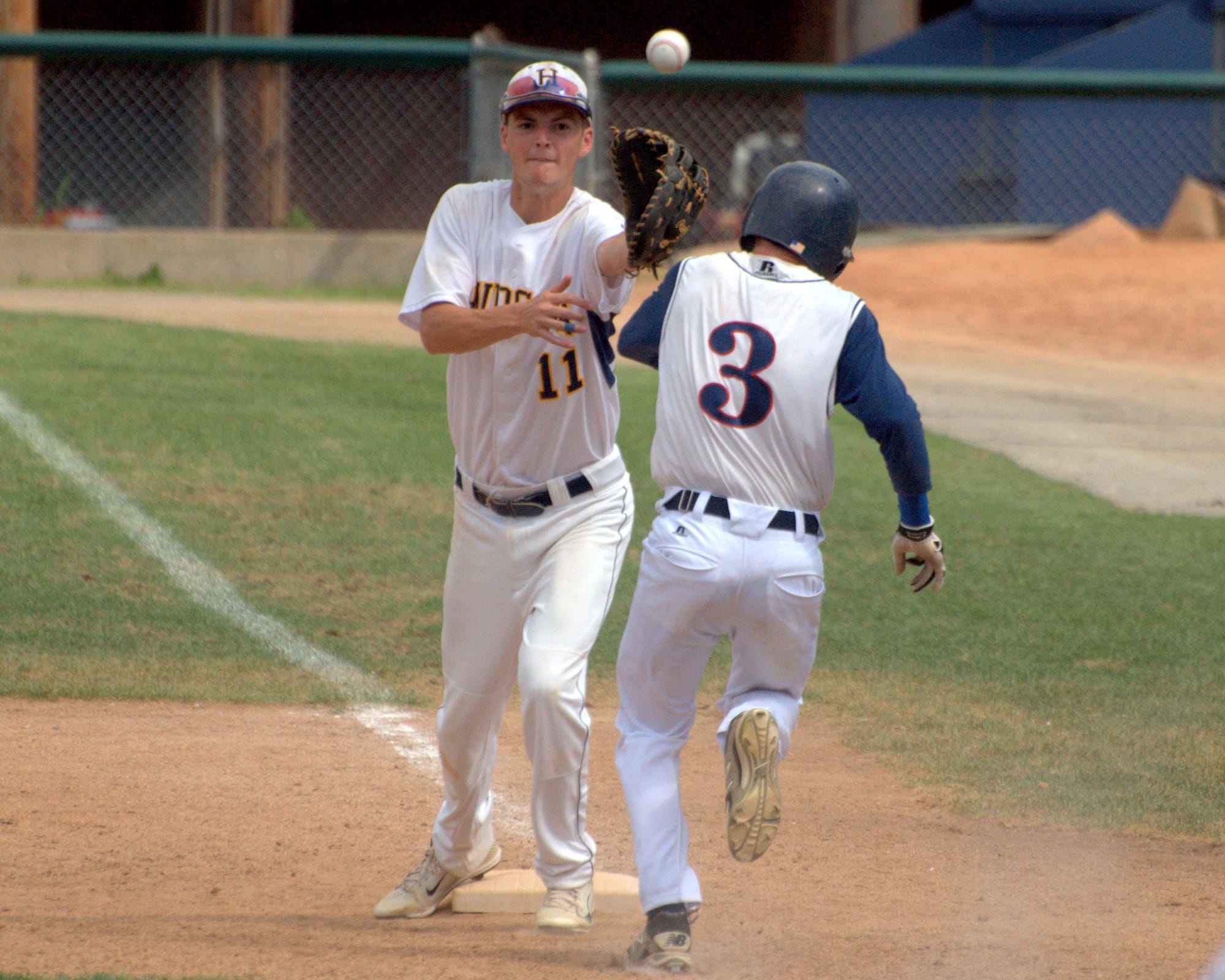 Hudson's Connor Whittemore waits for a throw as Dover's Jared Gagne races down the line.
