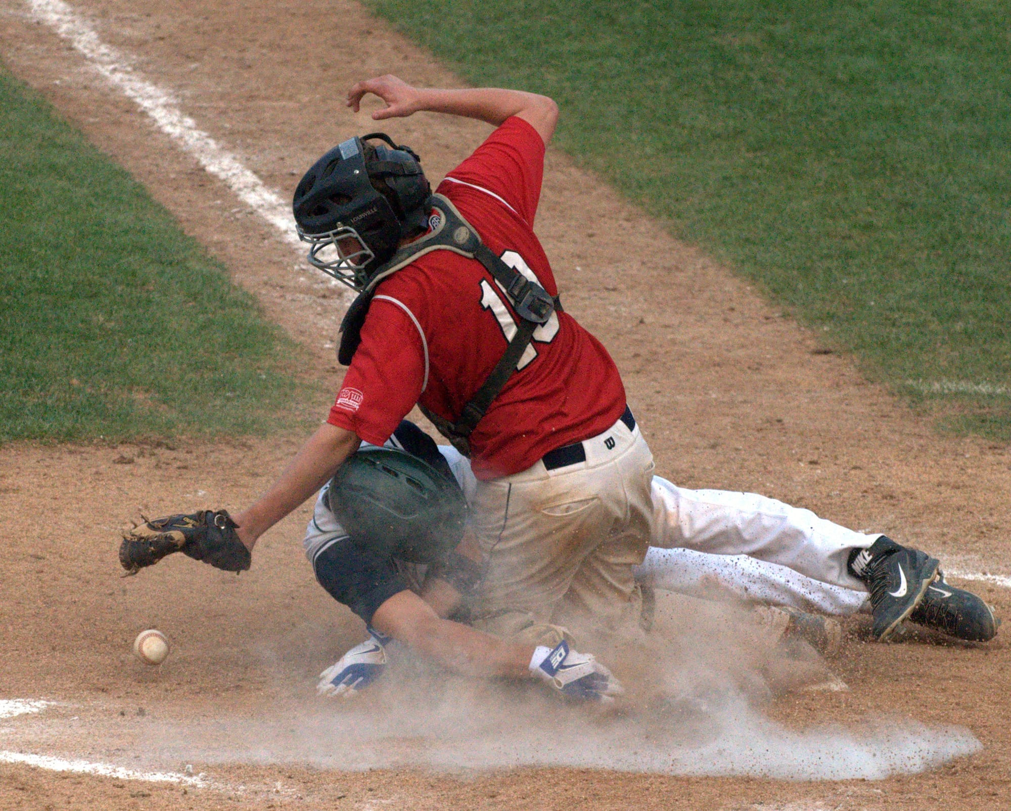 Dover's Mike Wasserman slides into home as the ball gets away from Lebanon's Tanner Sims.