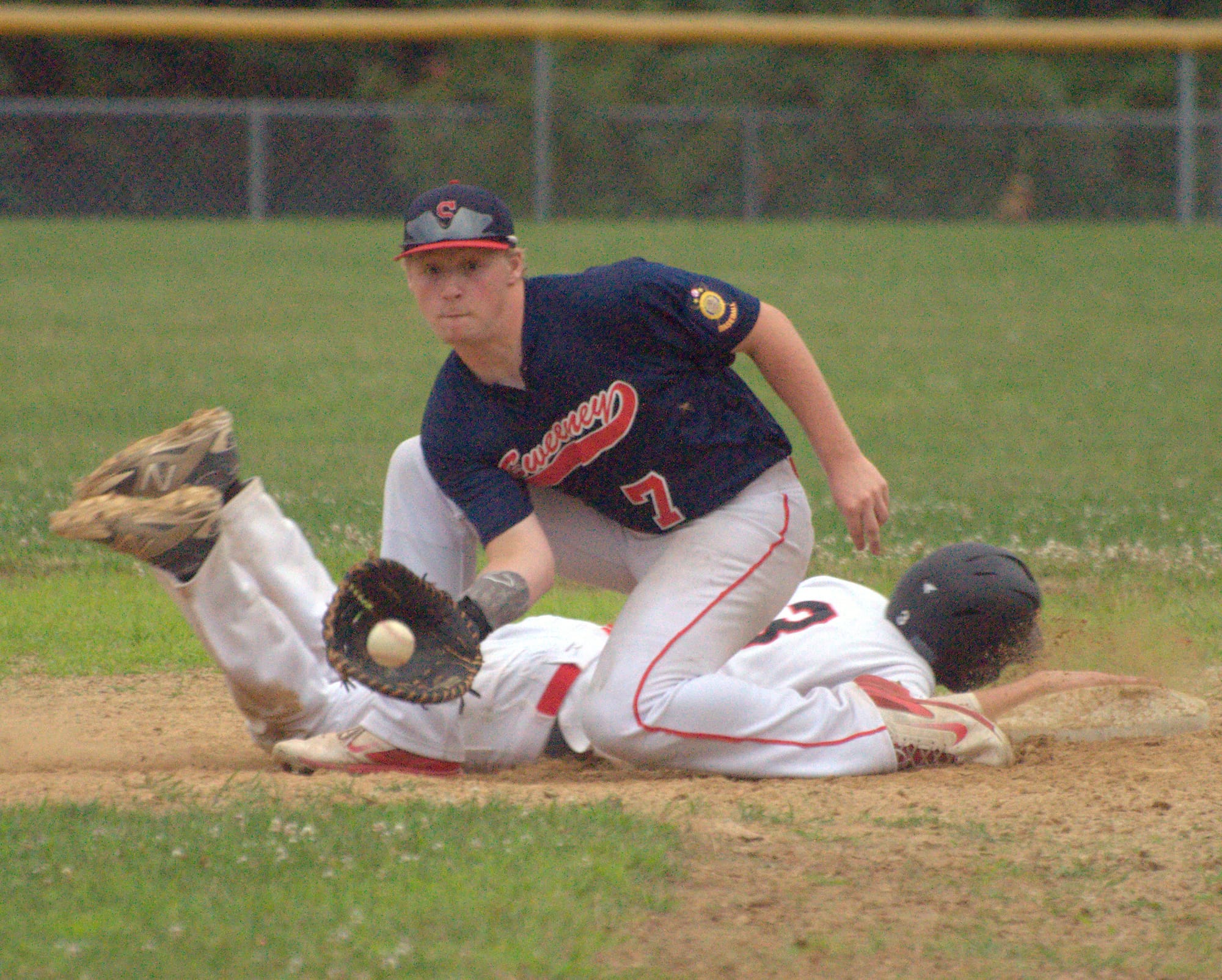 Sweeney's Grant Corbett fields a pickoff attempt as Milford's Tommy Bennett dives back into first on Monday. For more photos, go to the Photo Album.
