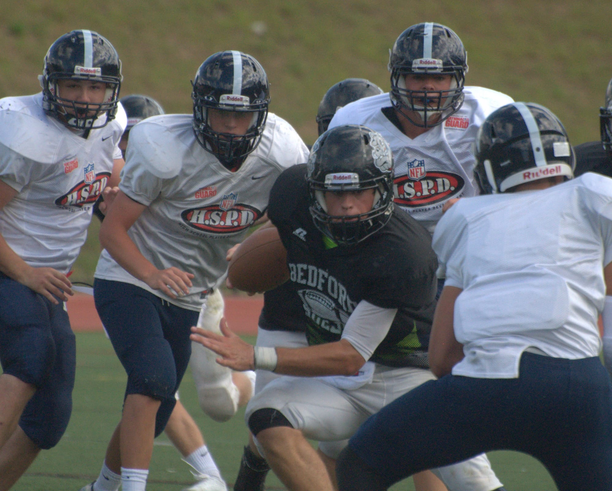Bedford's Mike Vailas makes his way through the Nashua North defense during Saturday's scrimmage.