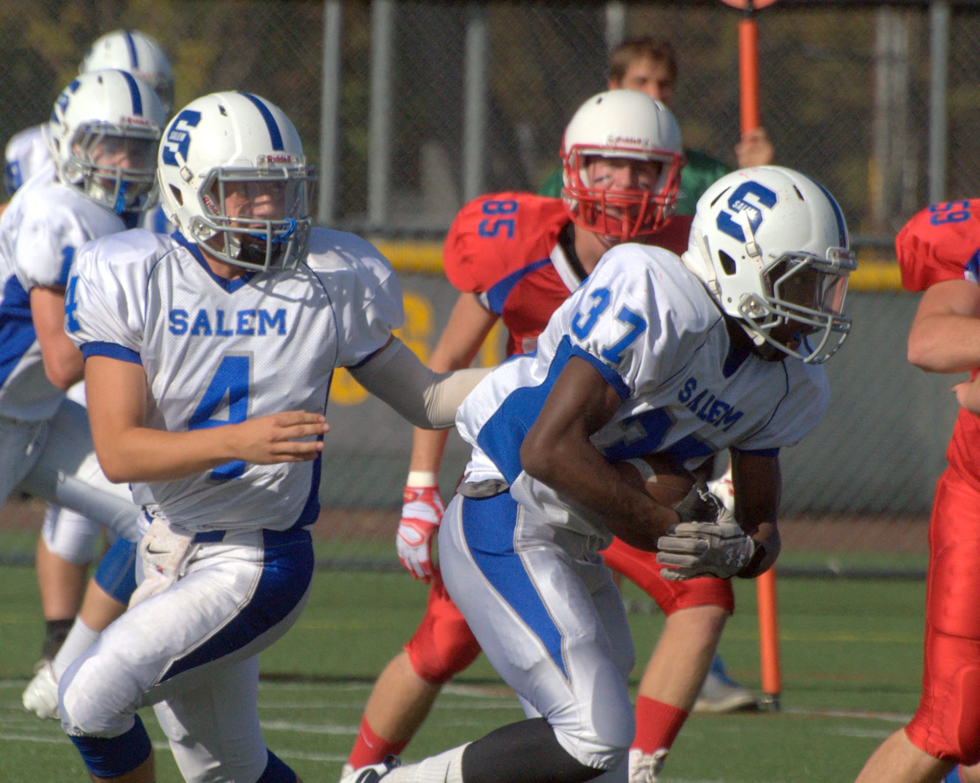 Salem's John Cerretani hands off to Charles Sibanda during Friday's scrimmage against Trinity.