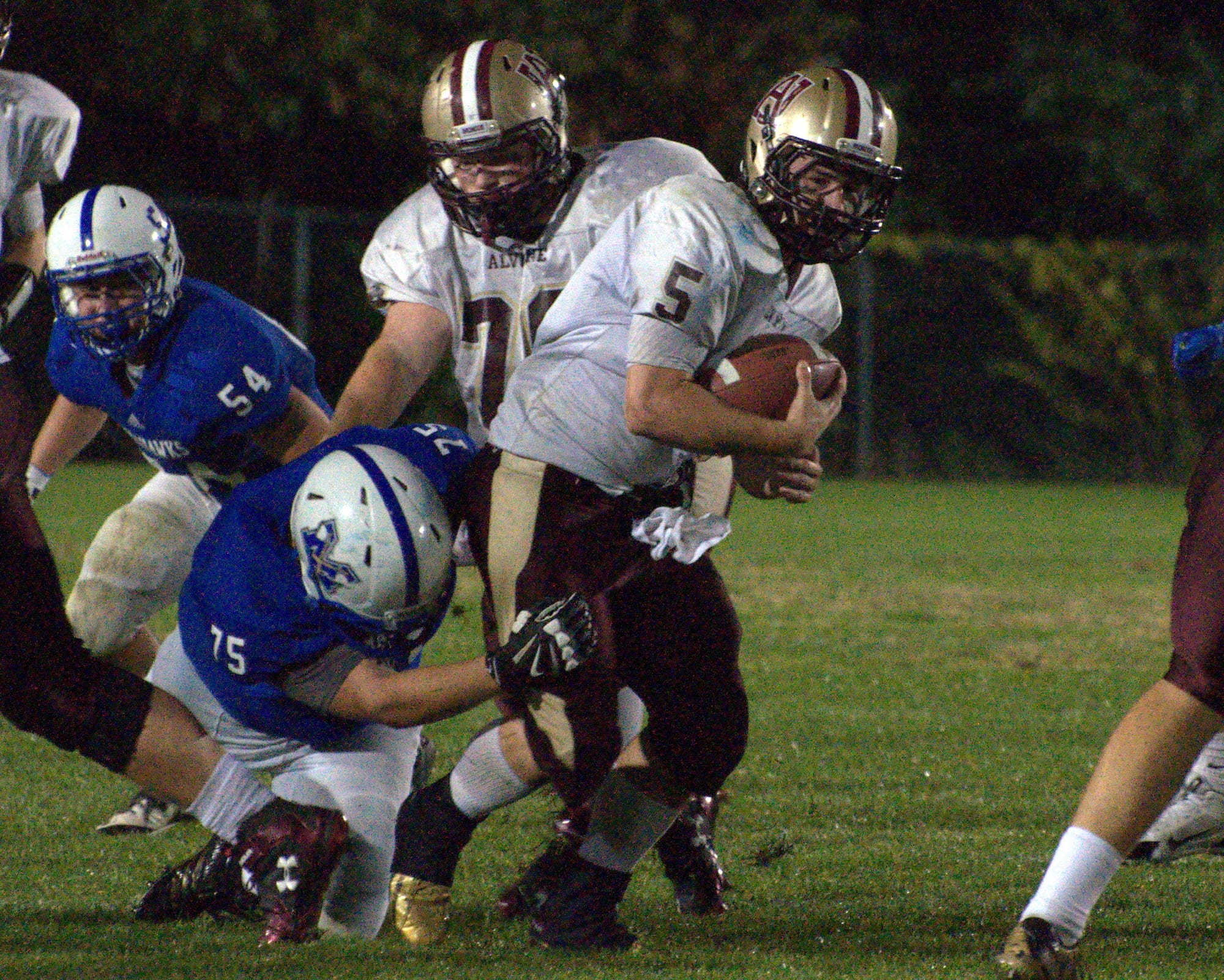 Alvirne's Jack Mahoney fights off a tackle as he picks up yards during Friday's game against Merrimack.