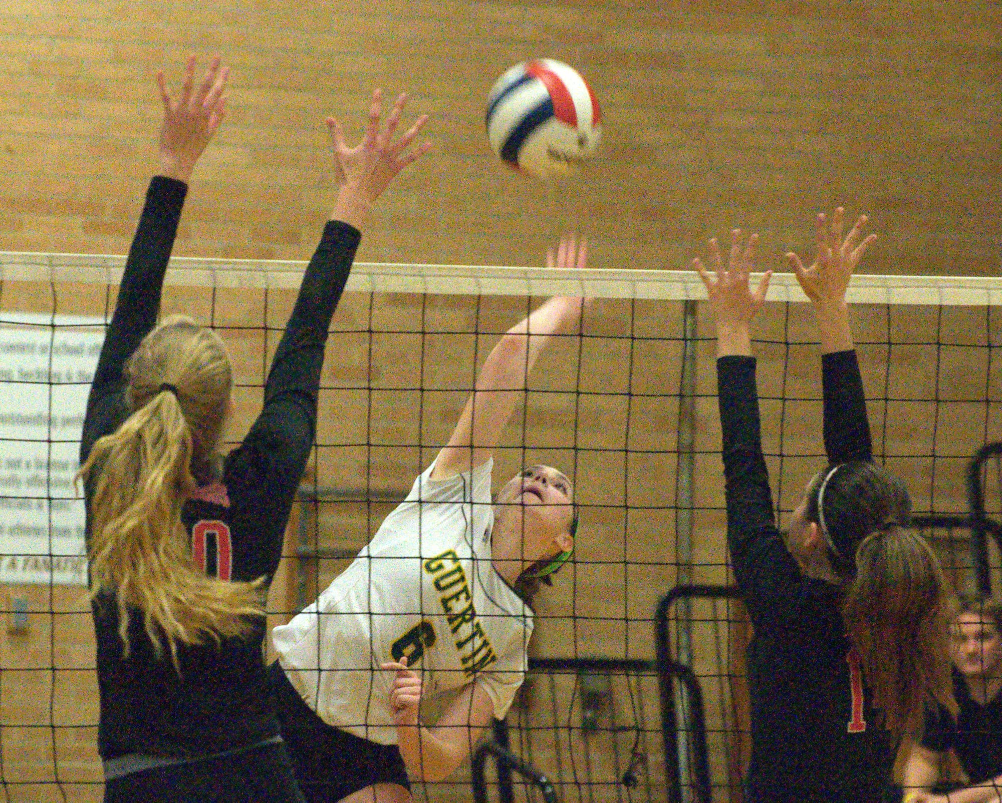 Bishop Guertin's Lexie Cambray tries to hit the ball between two Bedford players.