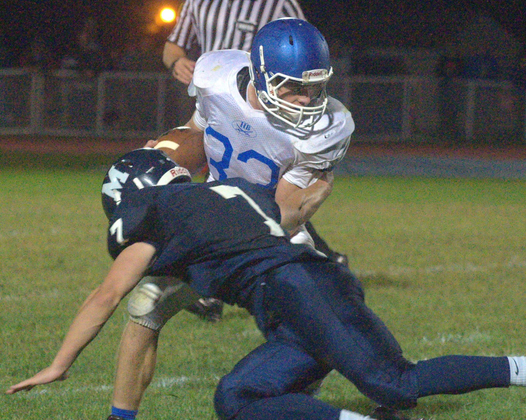 Hollis Brookline's Matt Ferenczhalmy fights off a tackle by Milford's Bryce Walker during Friday's game.