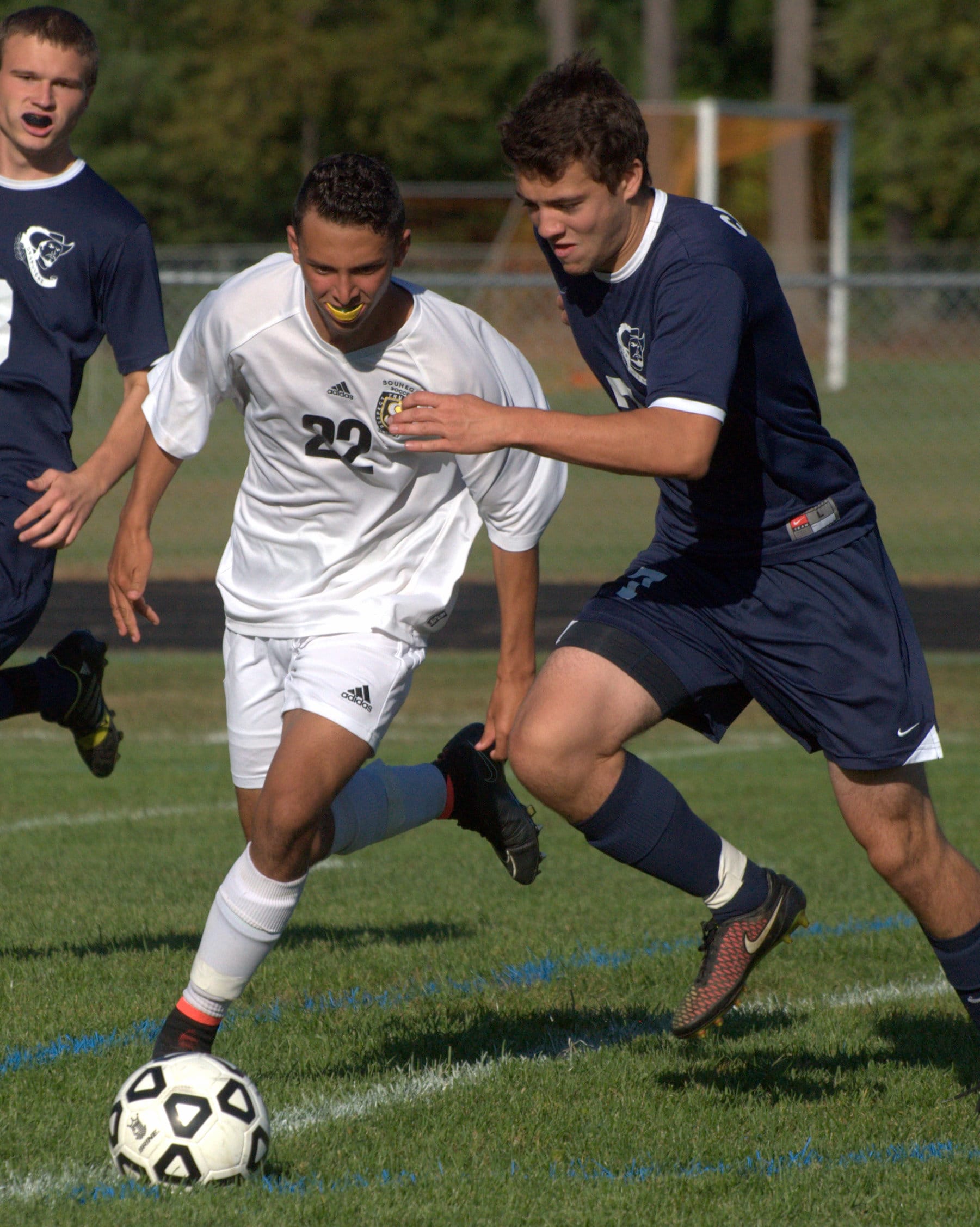 Souhegan's Ali Eweiss and Hollis Brookline's Sam Langley chase after the ball.