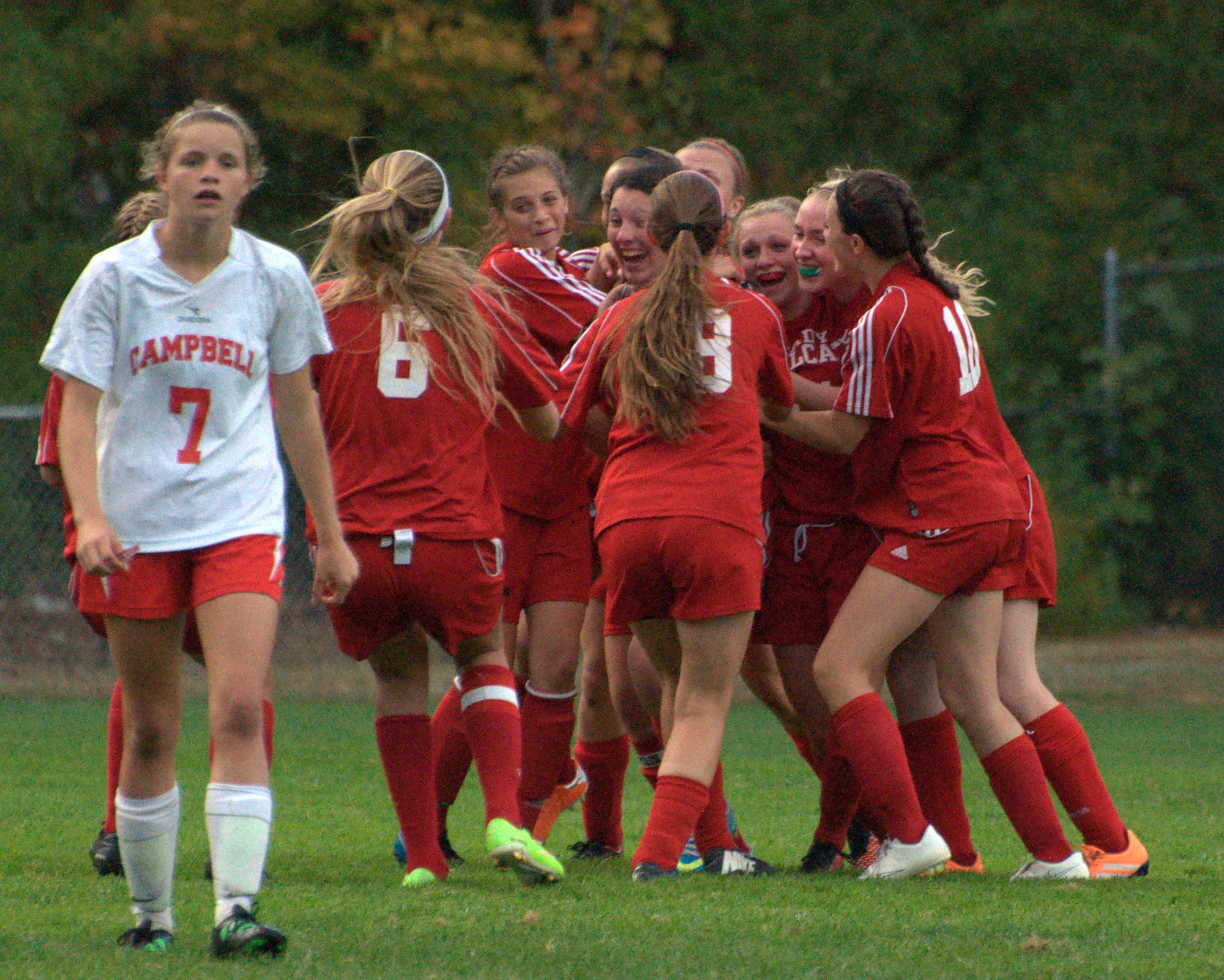 The Hillsboro-Deering girls soccer team celebrates after the game-winning goal as Campbell's Olivia Crema walks off the field on Thursday.