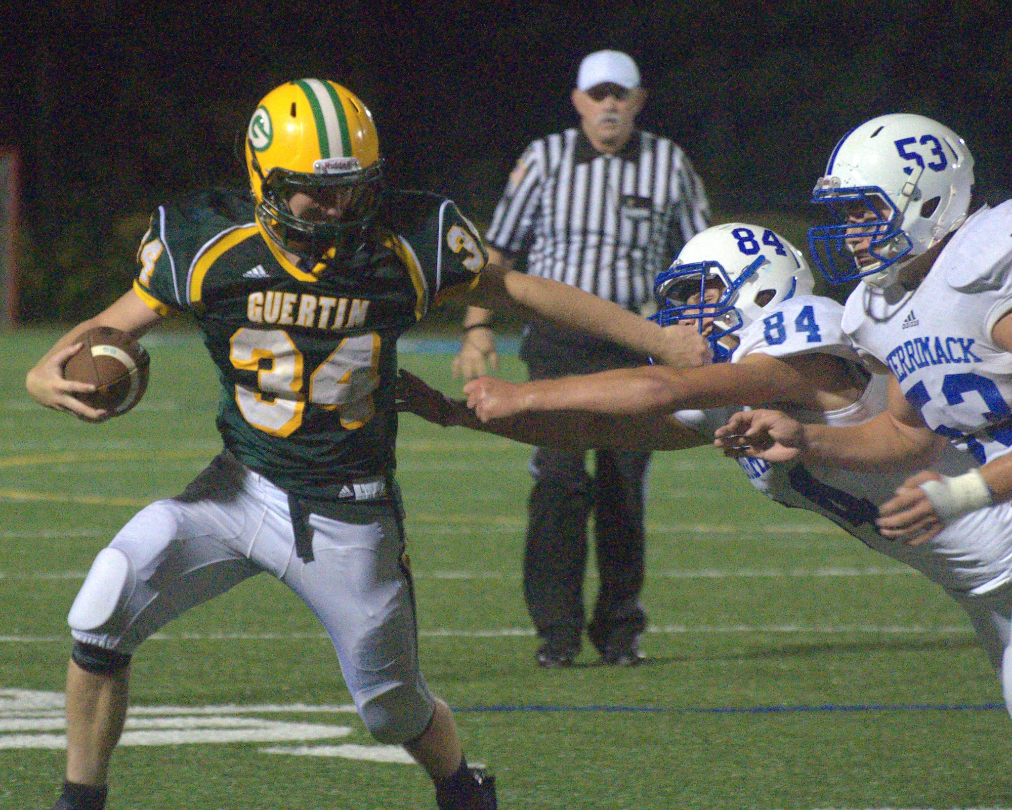 Bishop Guertin's Brandon Levesque stiff arms Merrimack's Daniel McKillop and Jason Theriault.