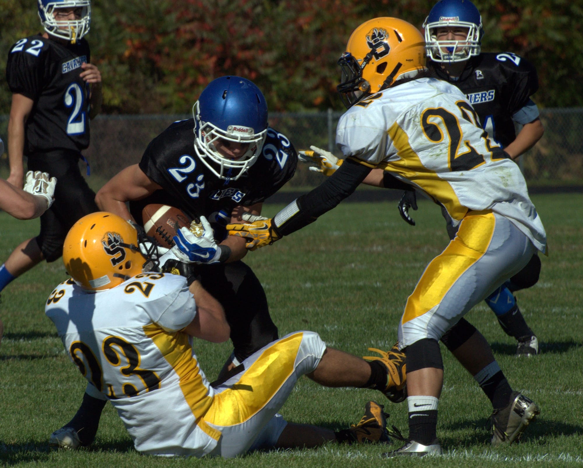 Souhegan's Tucker Aiello, left, and Zach Bossi try to bring down Hollis Brookline's Joe Brooks during Saturday's game.