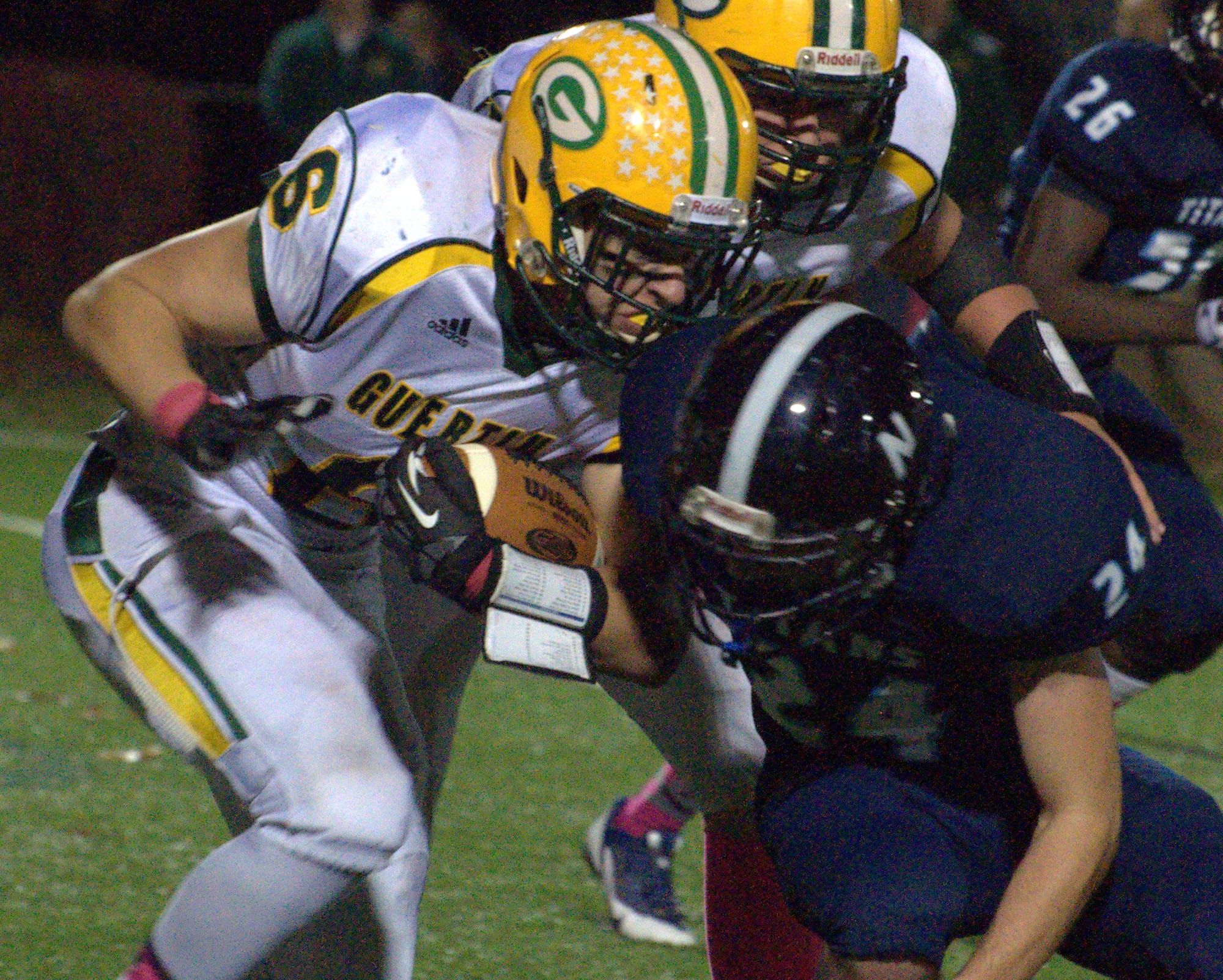 Bishop Guertin's Chase Hughes tries to fight off a tackle by Nashua North's Connor Baldassaro during Saturday's game.