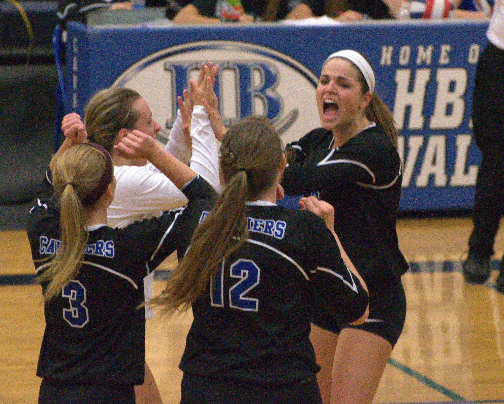 Madison Blake, right, celebrates with her Hollis Brookline teammates after winning a point during Wednesday's match against Londonderry.