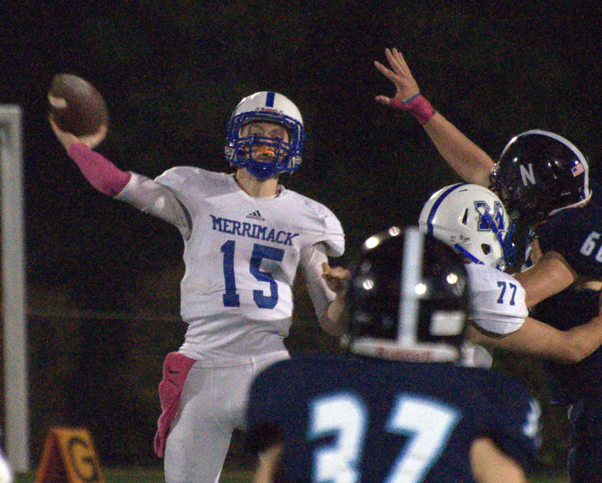 Merrimack's Justin Grassini passes as a Nashua North player tries to get a hand on the ball.