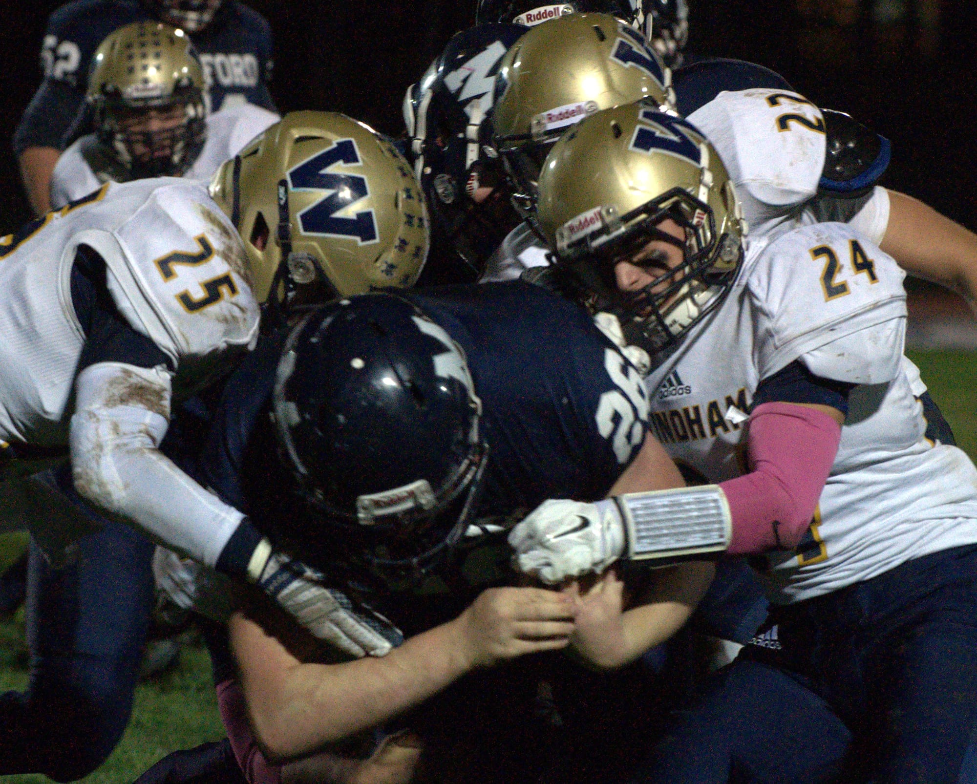 The Windham defense teams up to make a stop during Friday's game against Milford.
