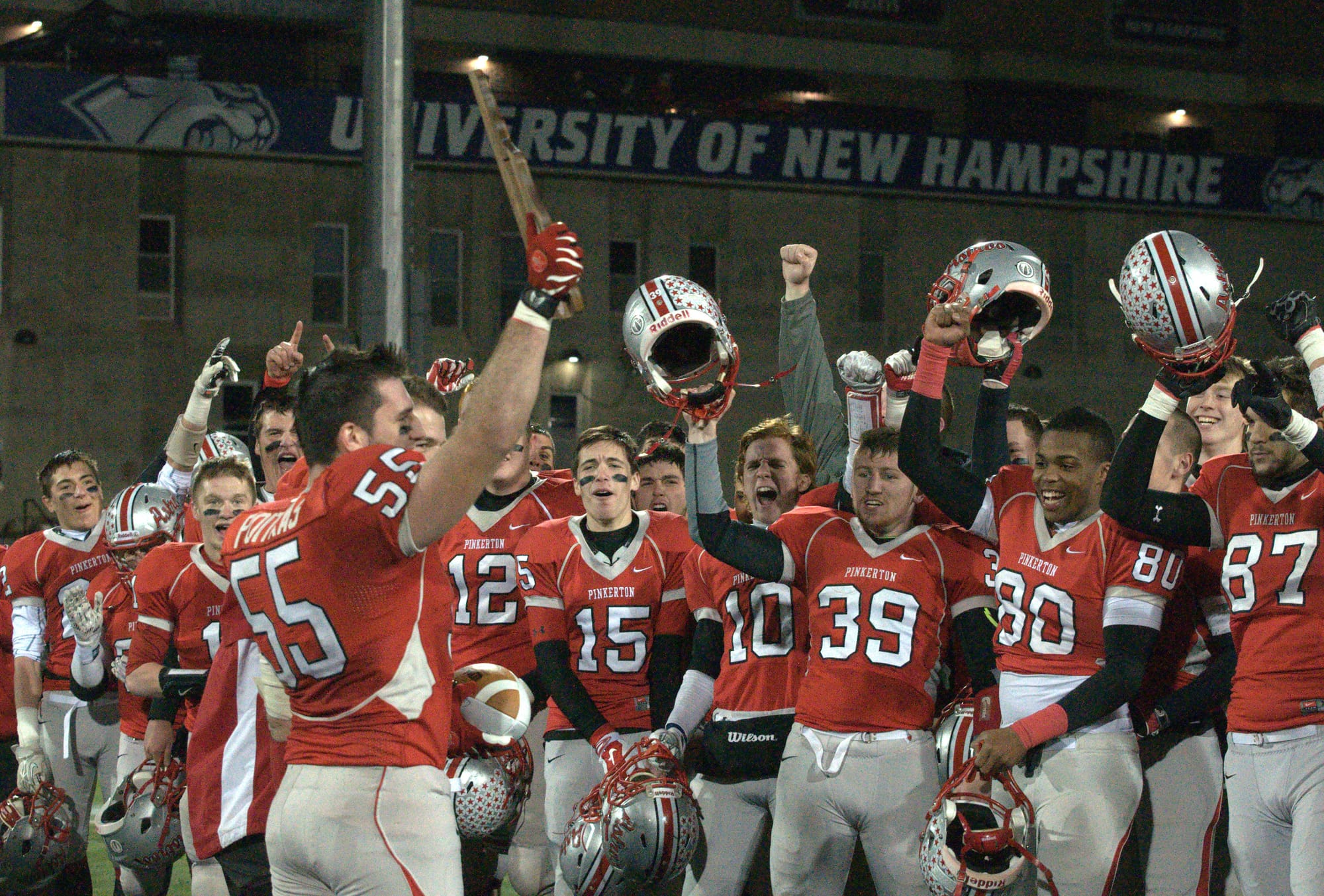 Pinkerton's Justin Poitras holds up the Division I championship plaque as his teammates celebrate after Saturday's win.